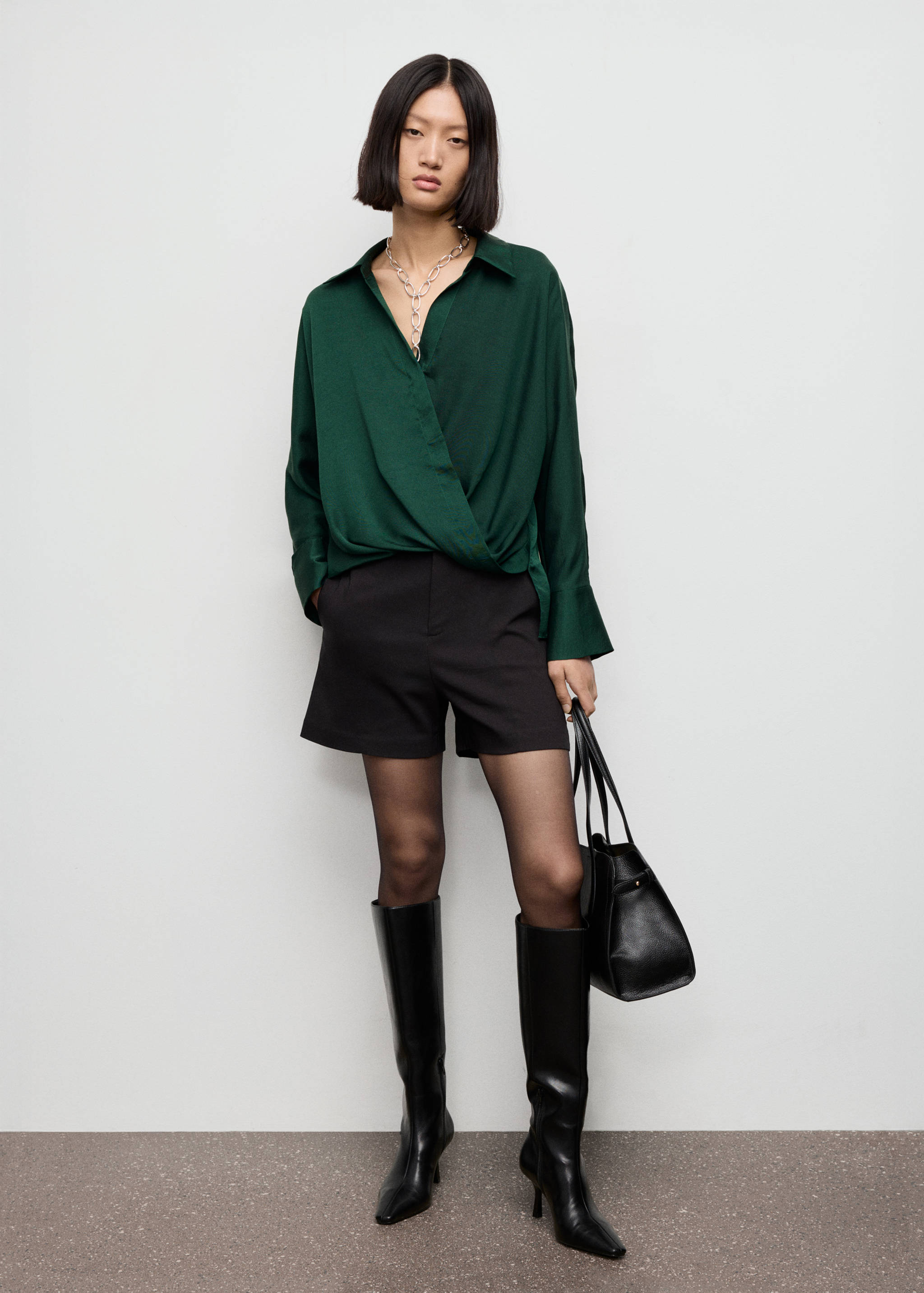 Dark green wrapped-front shirt worn with black shorts and boots.