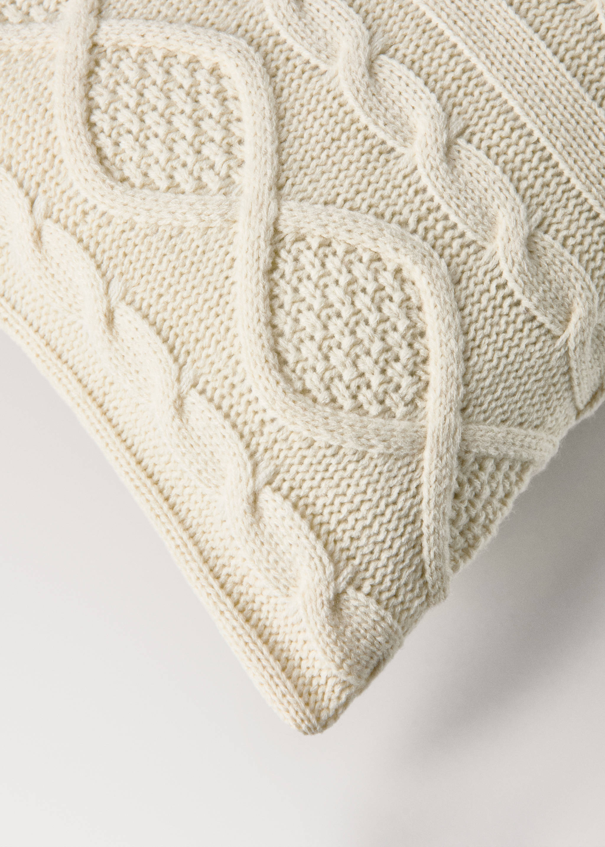 Off-white cushion cover with a textured cable-knit pattern.