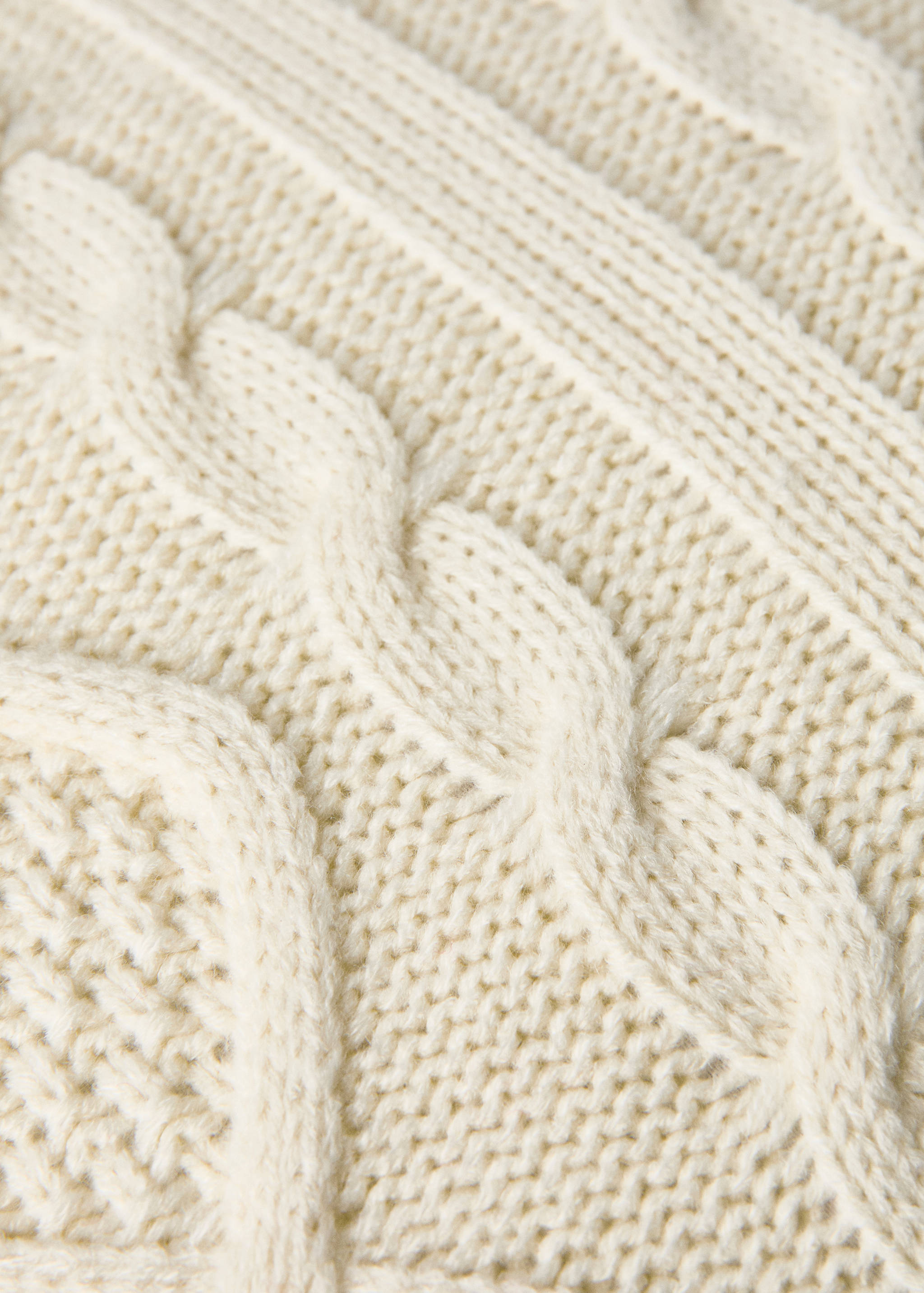 Off-white cushion cover with a textured cable knit detail.