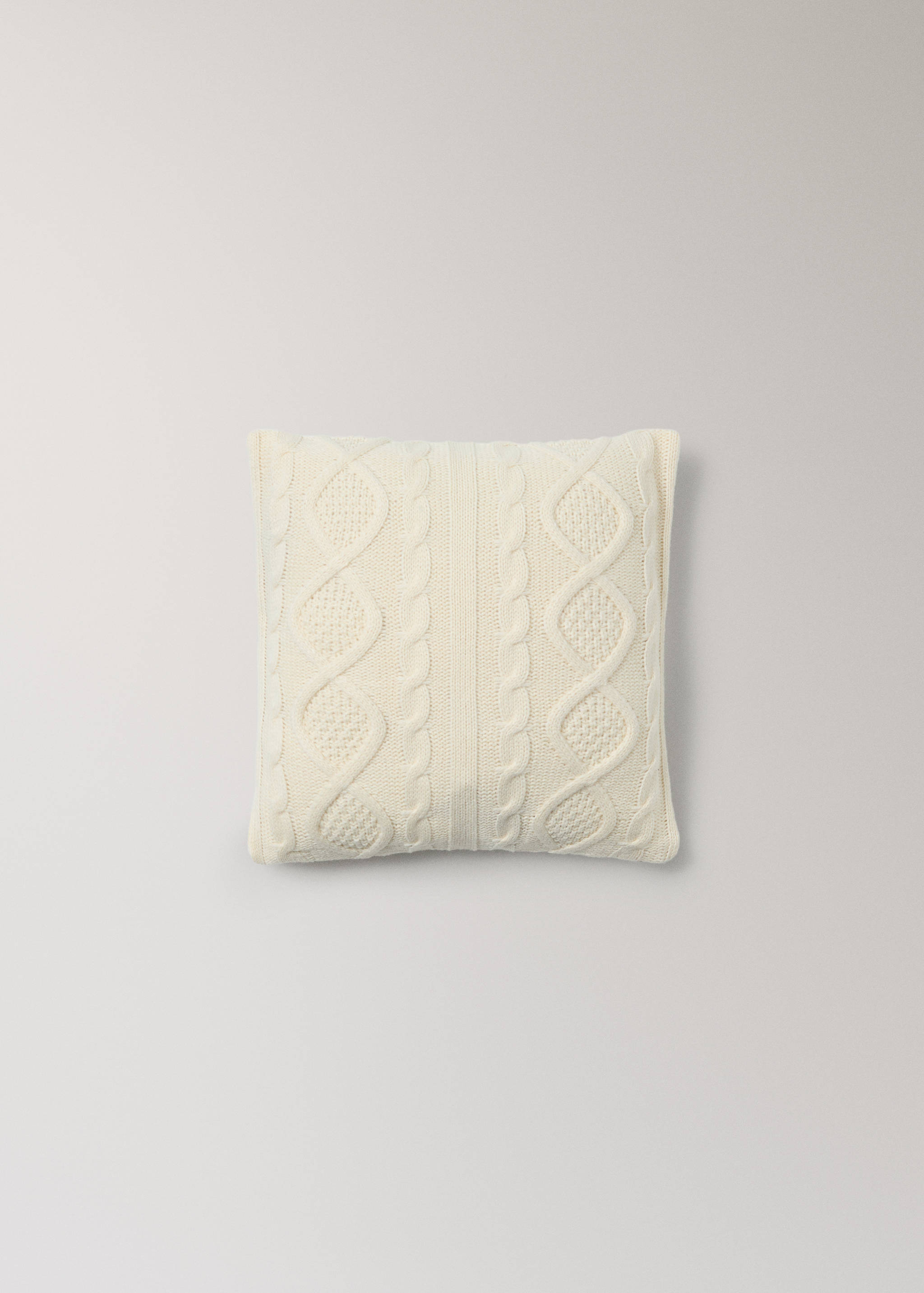 Off-white cable knit cushion cover with a textured diamond pattern.