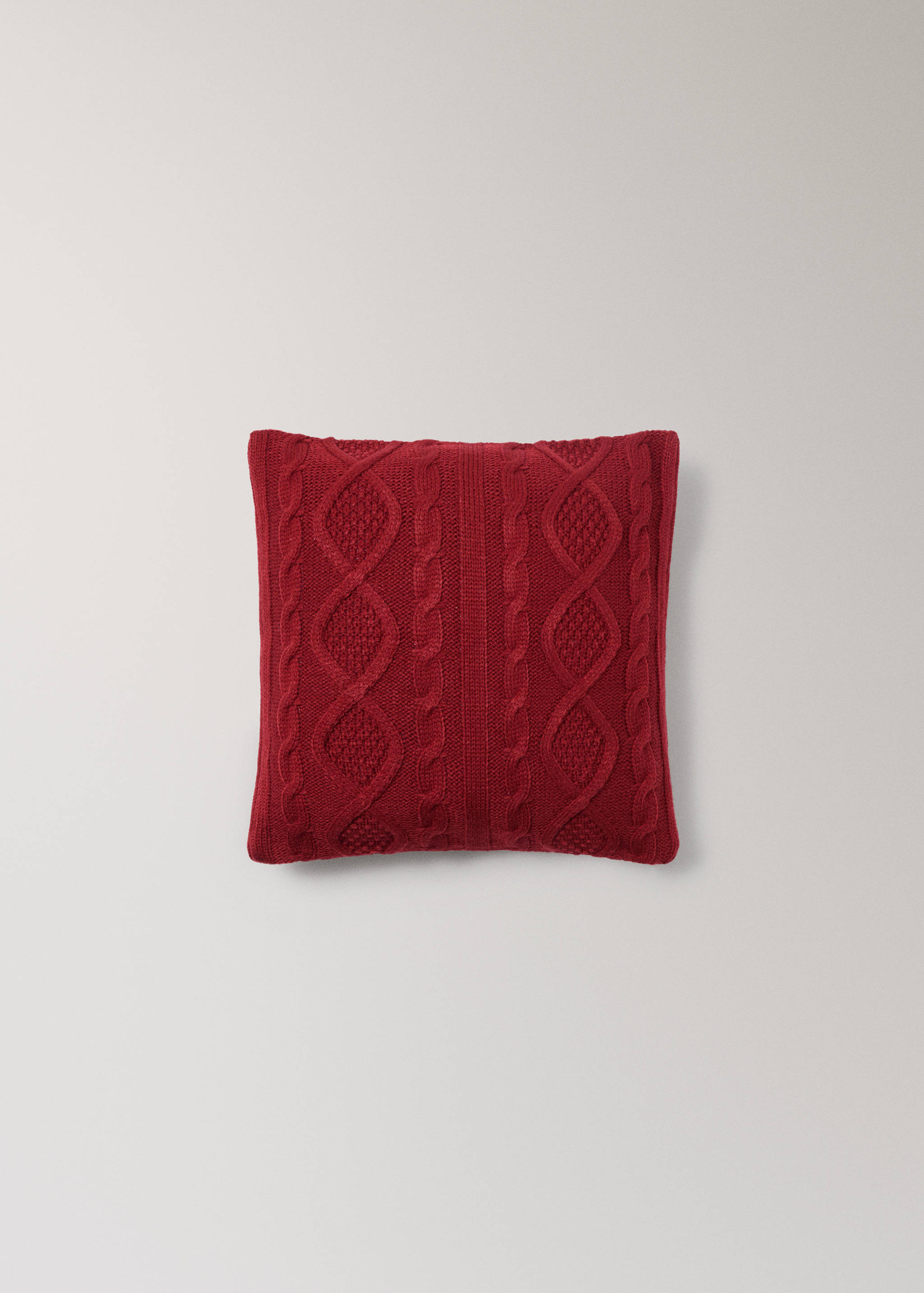 Red cable-knit cushion cover.