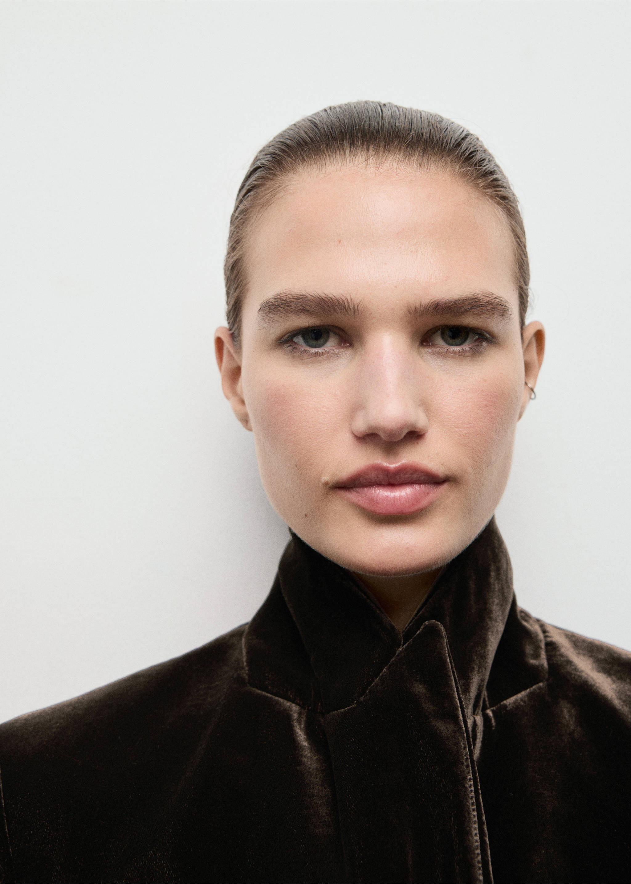 Close-up of a model wearing a dark brown velvet blazer with a structured collar., Chocolate. Ref: 17069406-00.