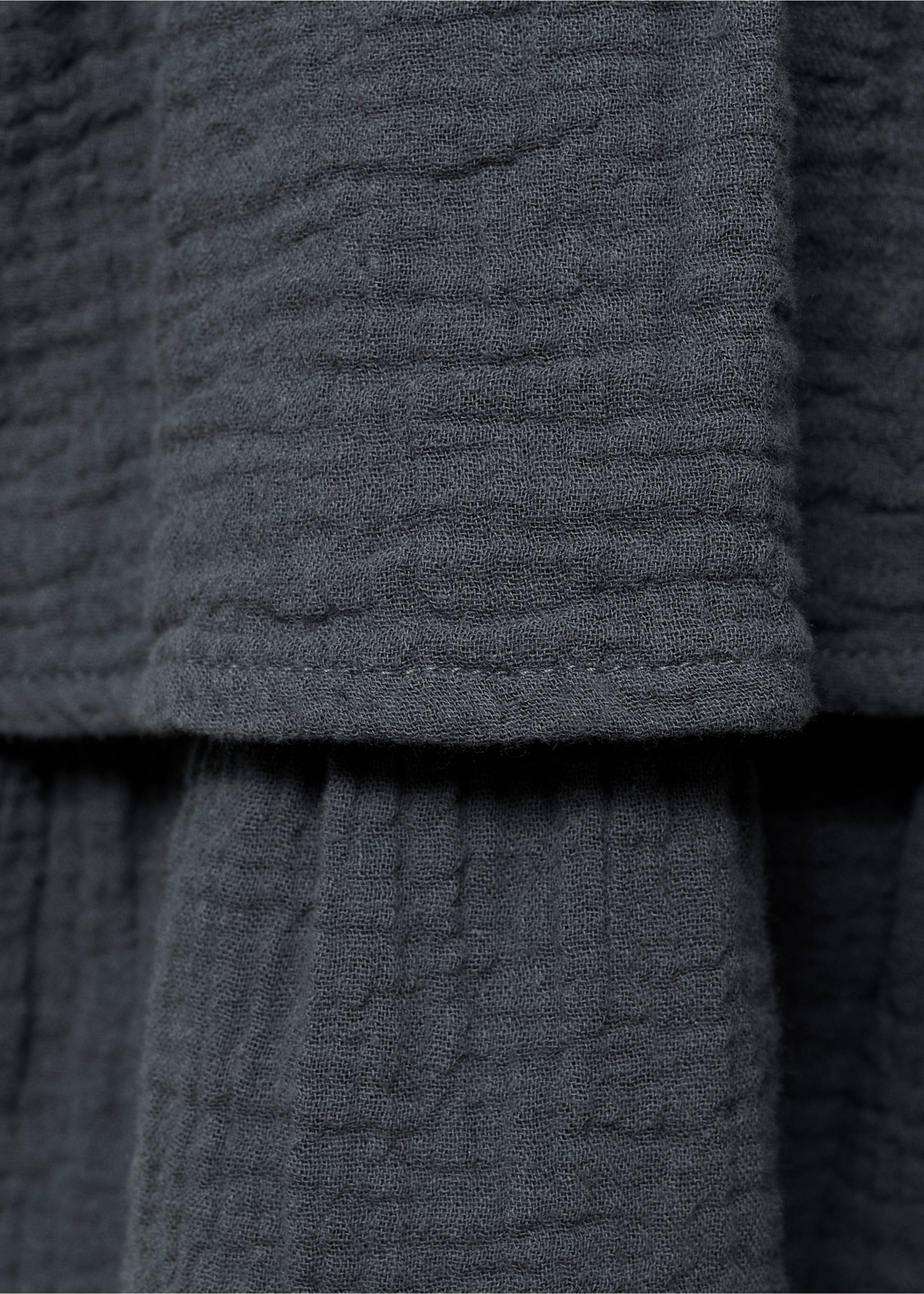 Dark grey dress detail showing textured muslin fabric and layered tiers., Charcoal. Ref: 17074410-00.