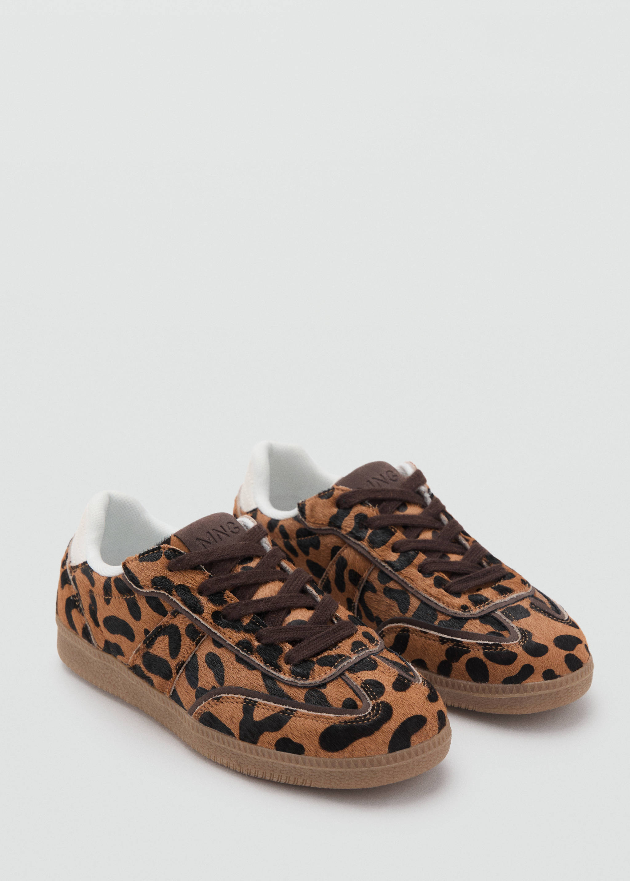 Leopard print faux-fur trainers with brown laces and gum soles.