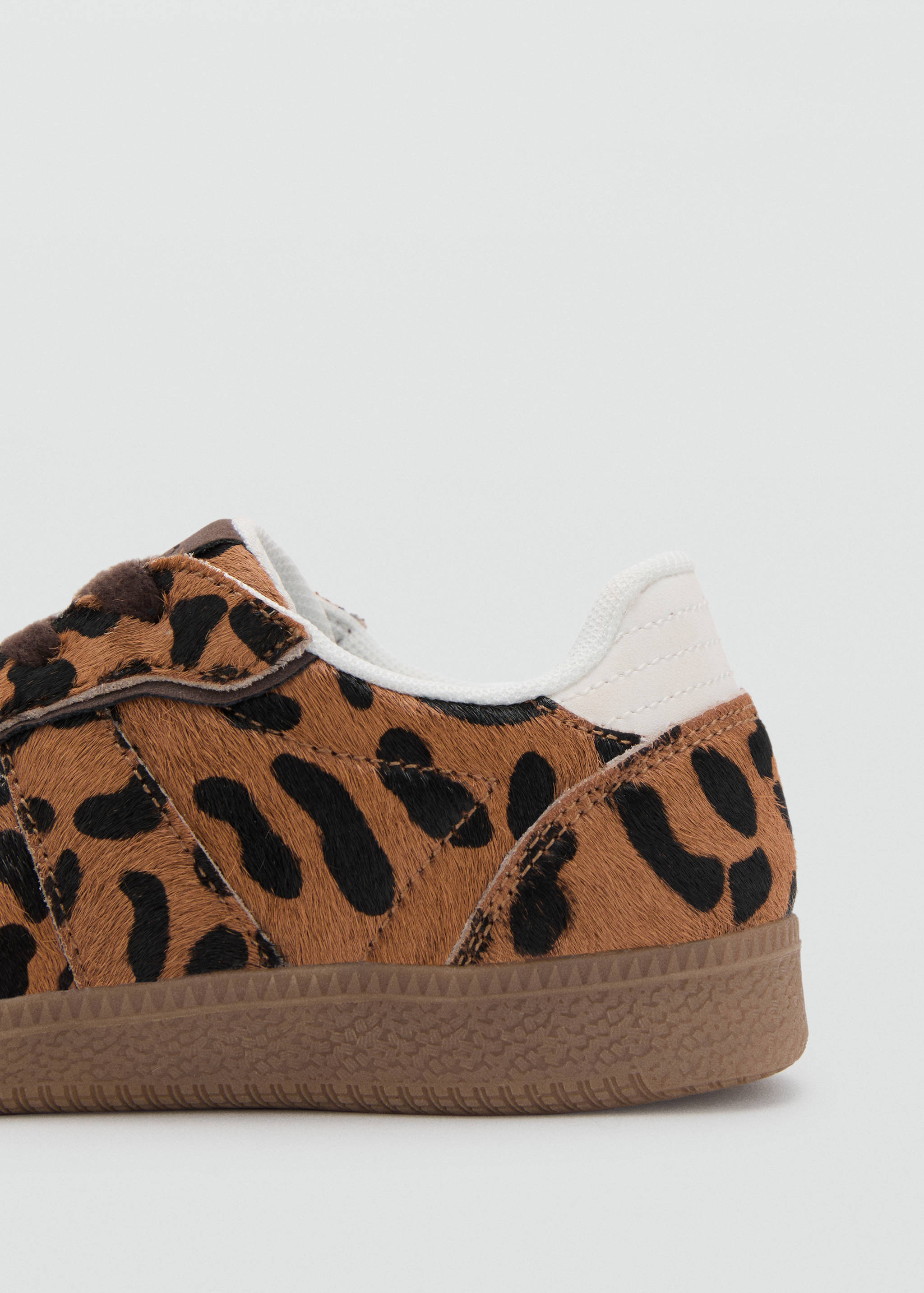 Close-up of children's leopard print faux-fur trainers with gum soles.