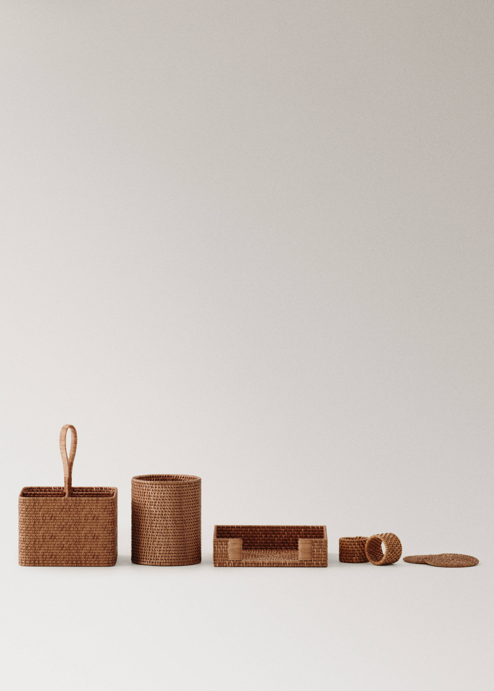 Set of woven brown rattan kitchen and table accessories.