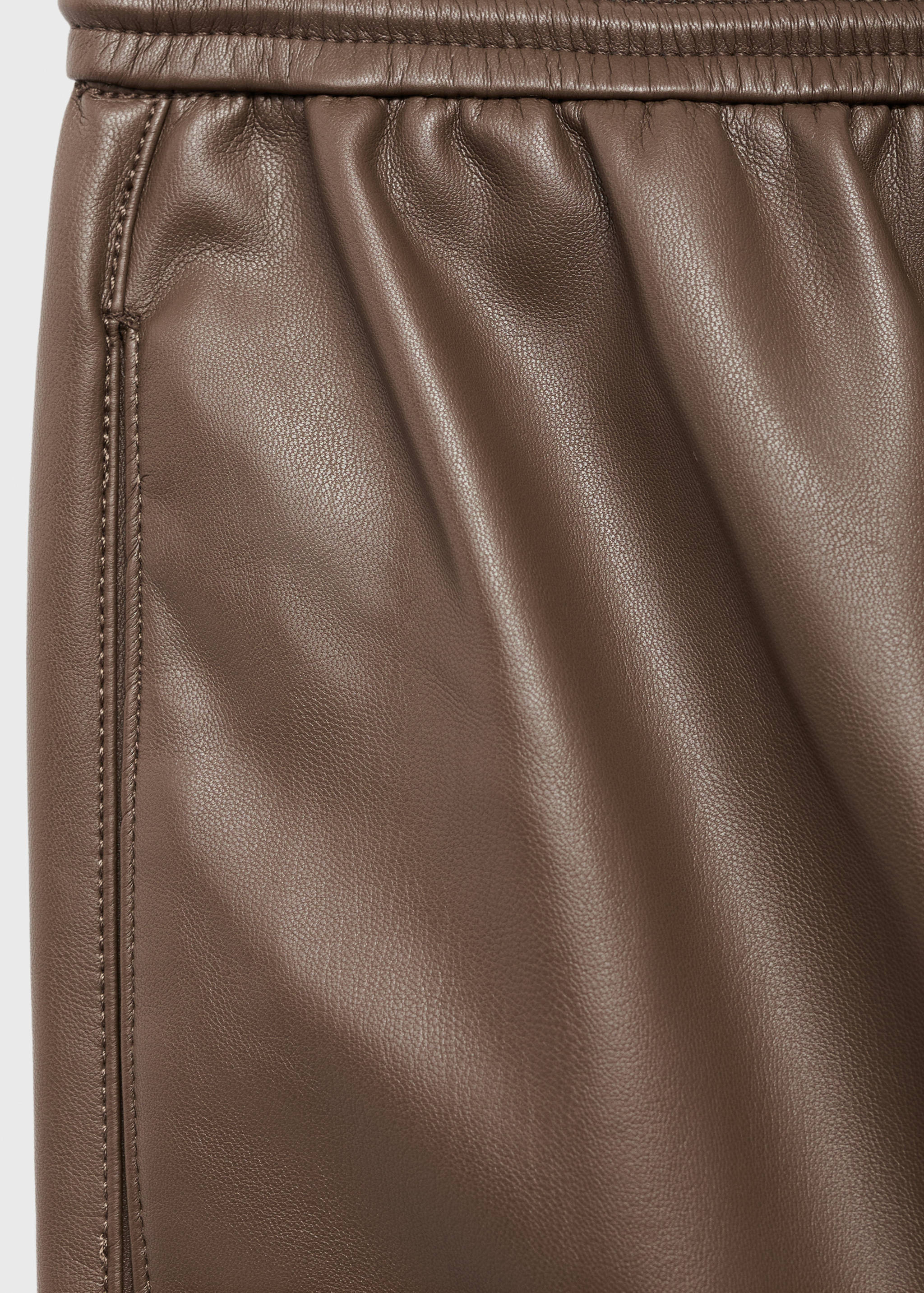 Brown leather trousers fabric detail showing the elasticated waistband.