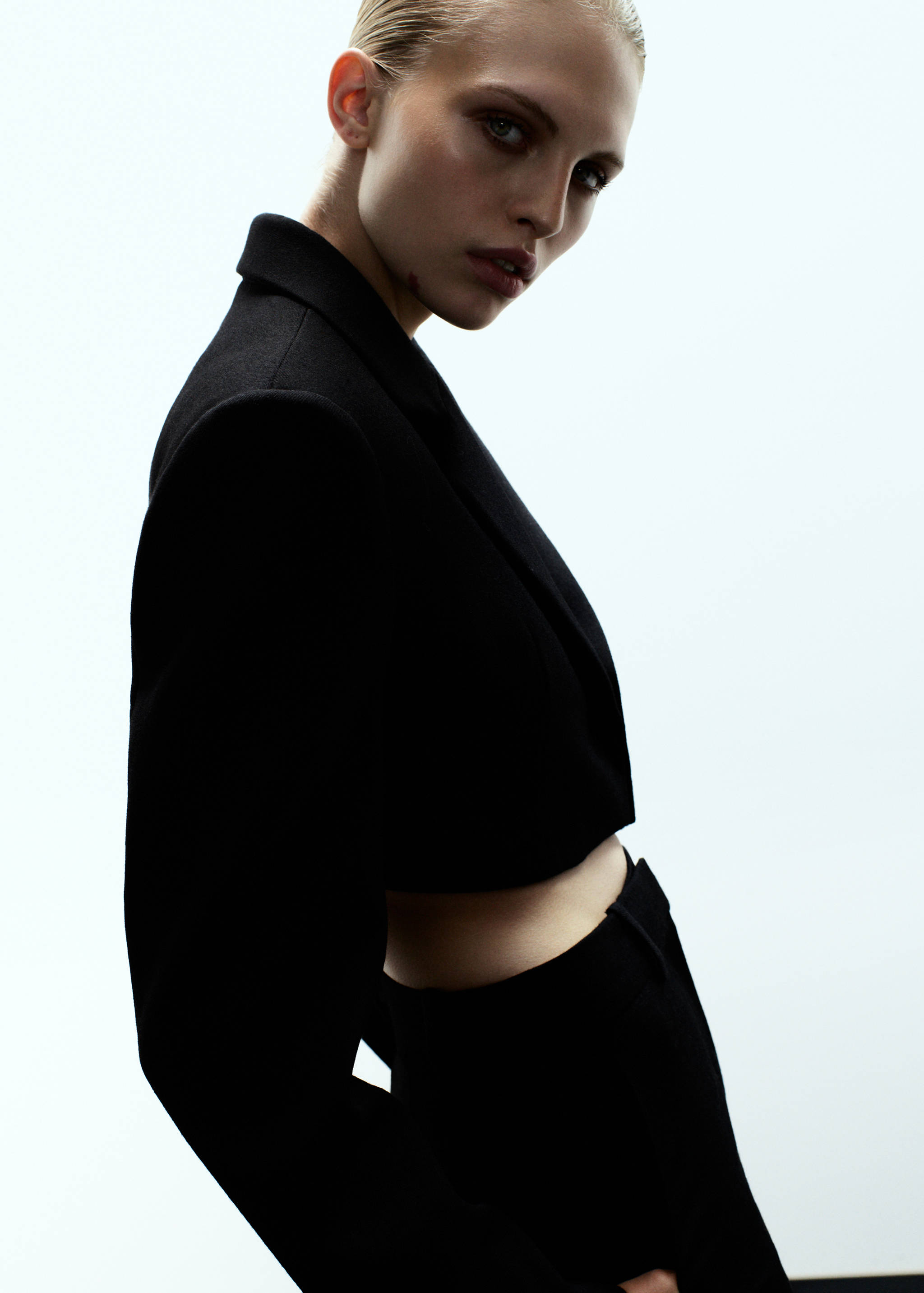 Black cropped blazer with a tailored lapel collar.