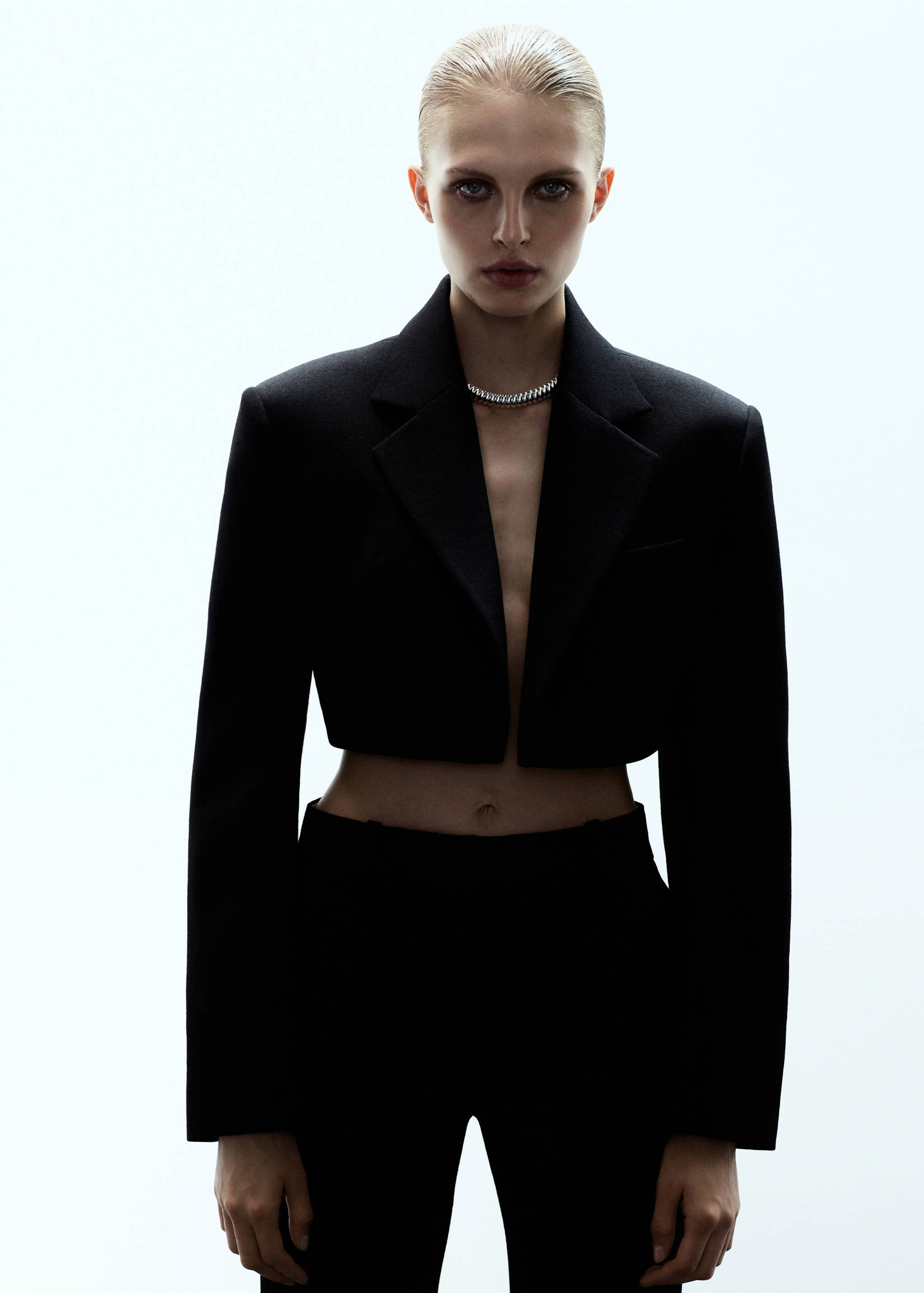 Black cropped blazer with structured shoulders and lapels.