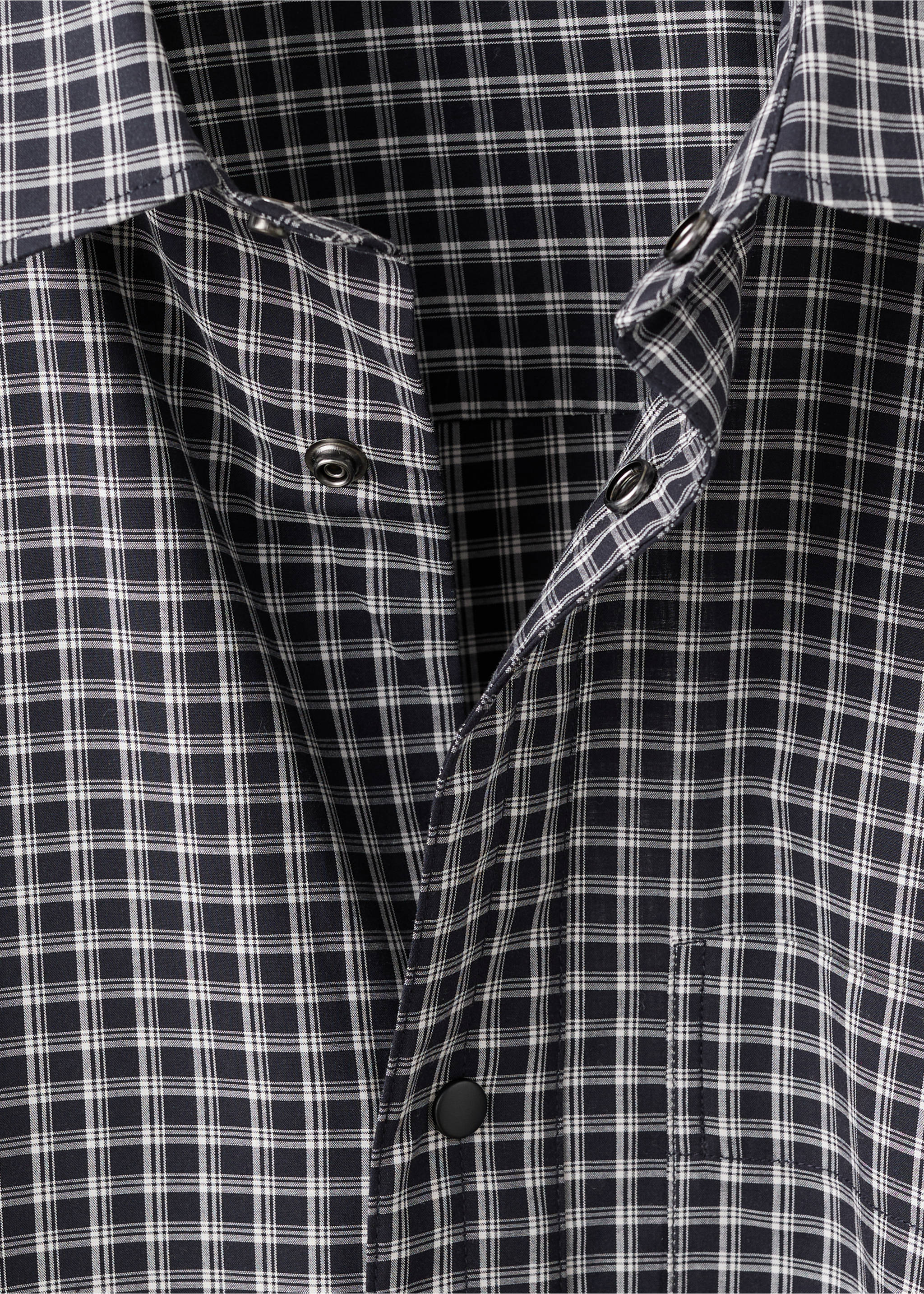 Close-up of a black and white checked shirt with a collar and snap-button placket., Black. Ref: 17079207-00.