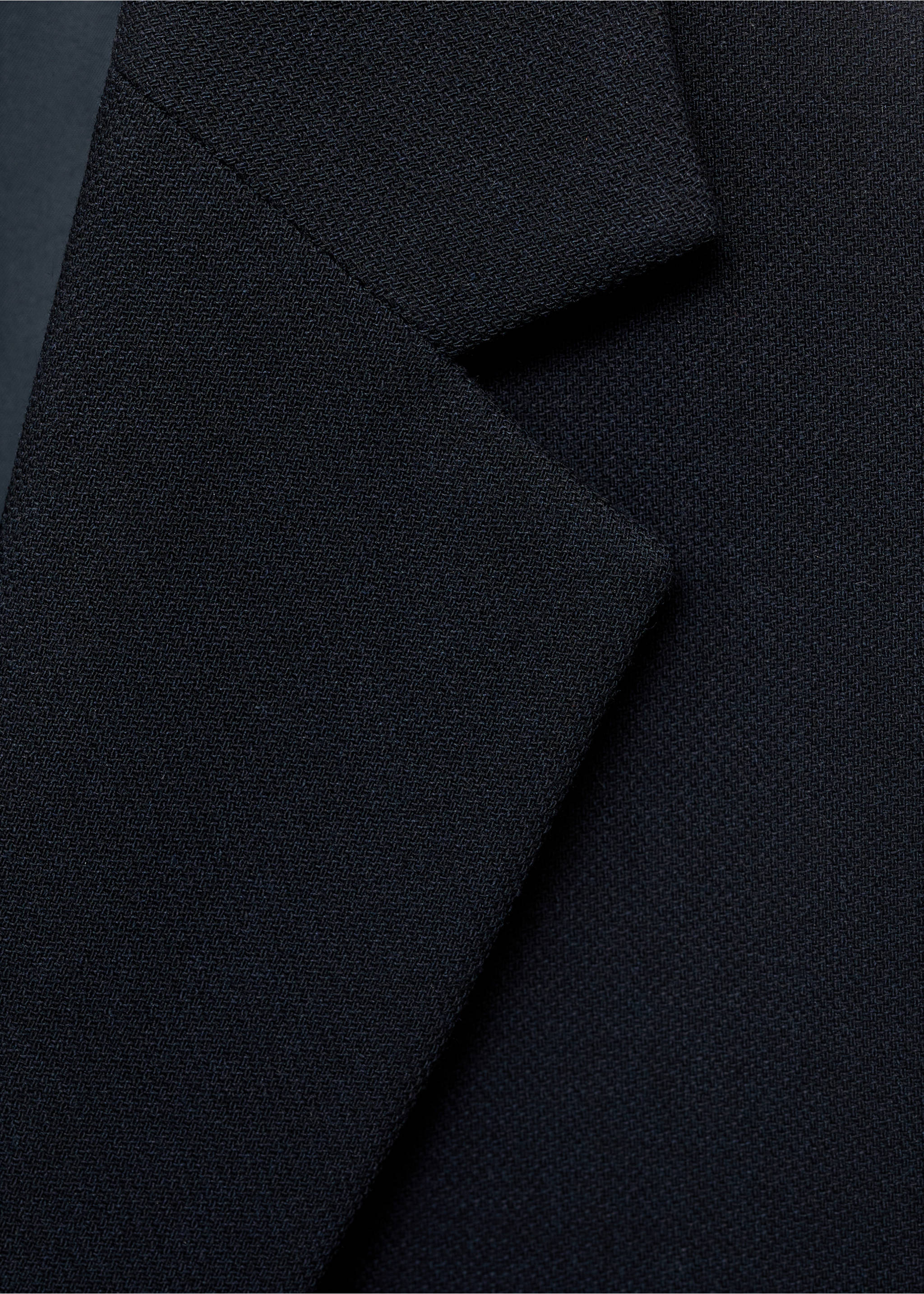 Close-up of the lapel and textured black fabric of a men's blazer., Navy. Ref: 17081184-00.