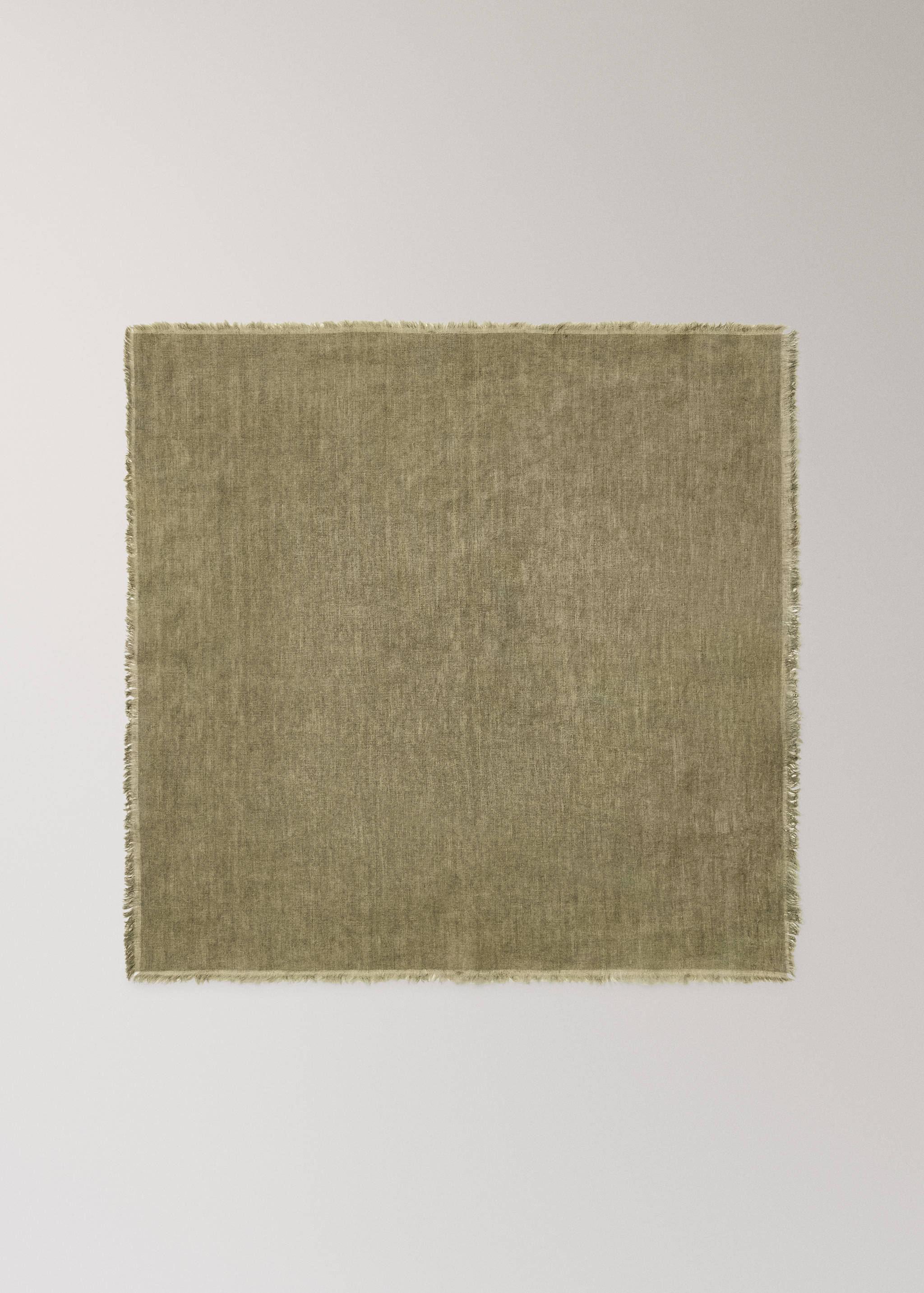 Green napkin with a textured woven design and frayed edges.