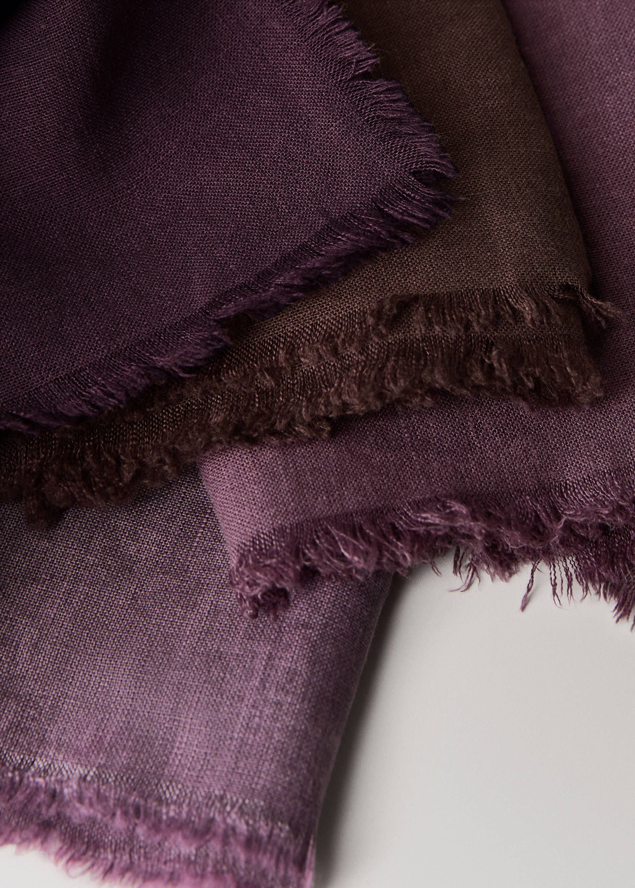 Close-up of deep purple cloth napkins with frayed edges.