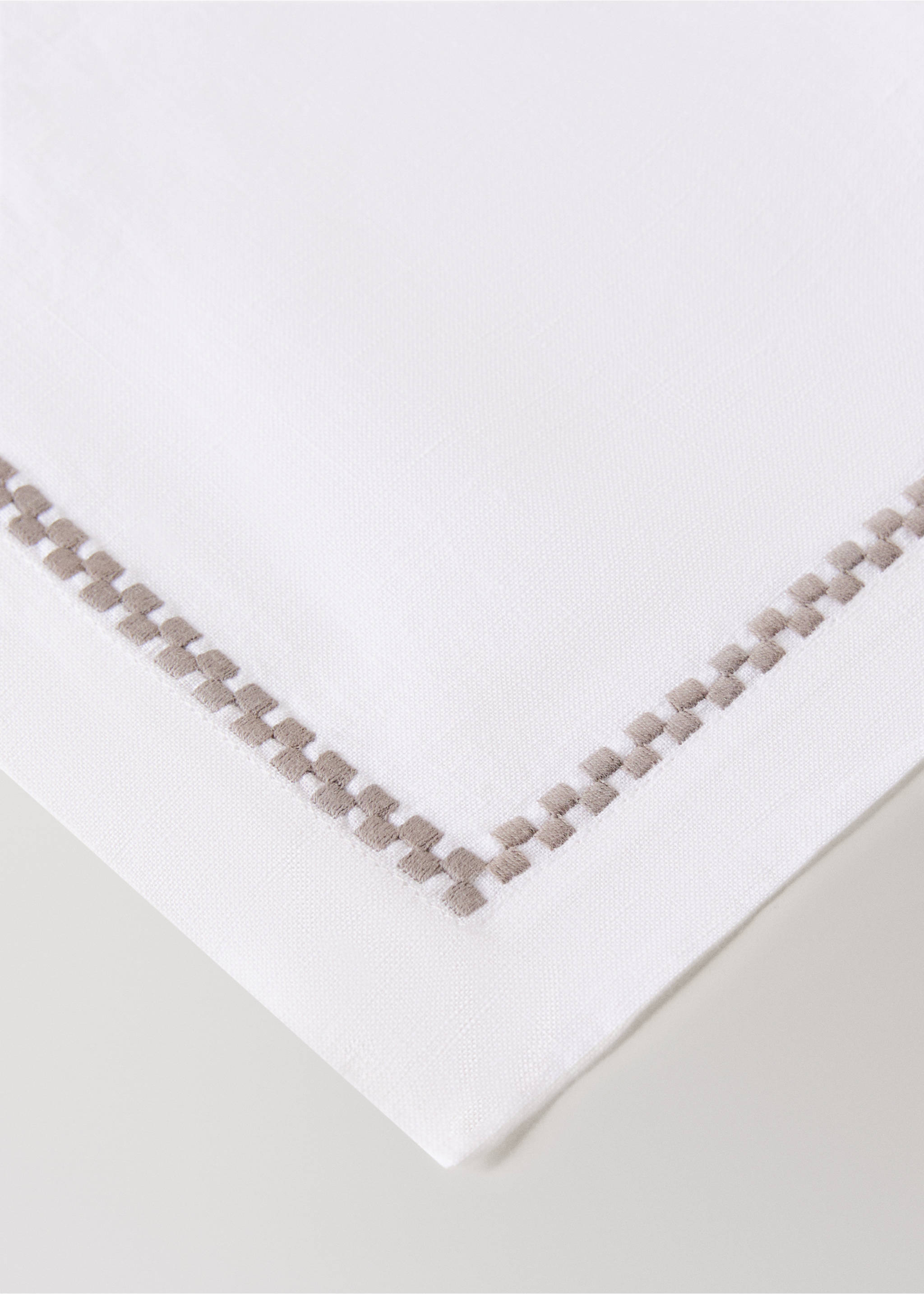 White placemat with an embroidered light grey-brown geometric border., Light/Pastel Brown. Ref: 17083826-00.
