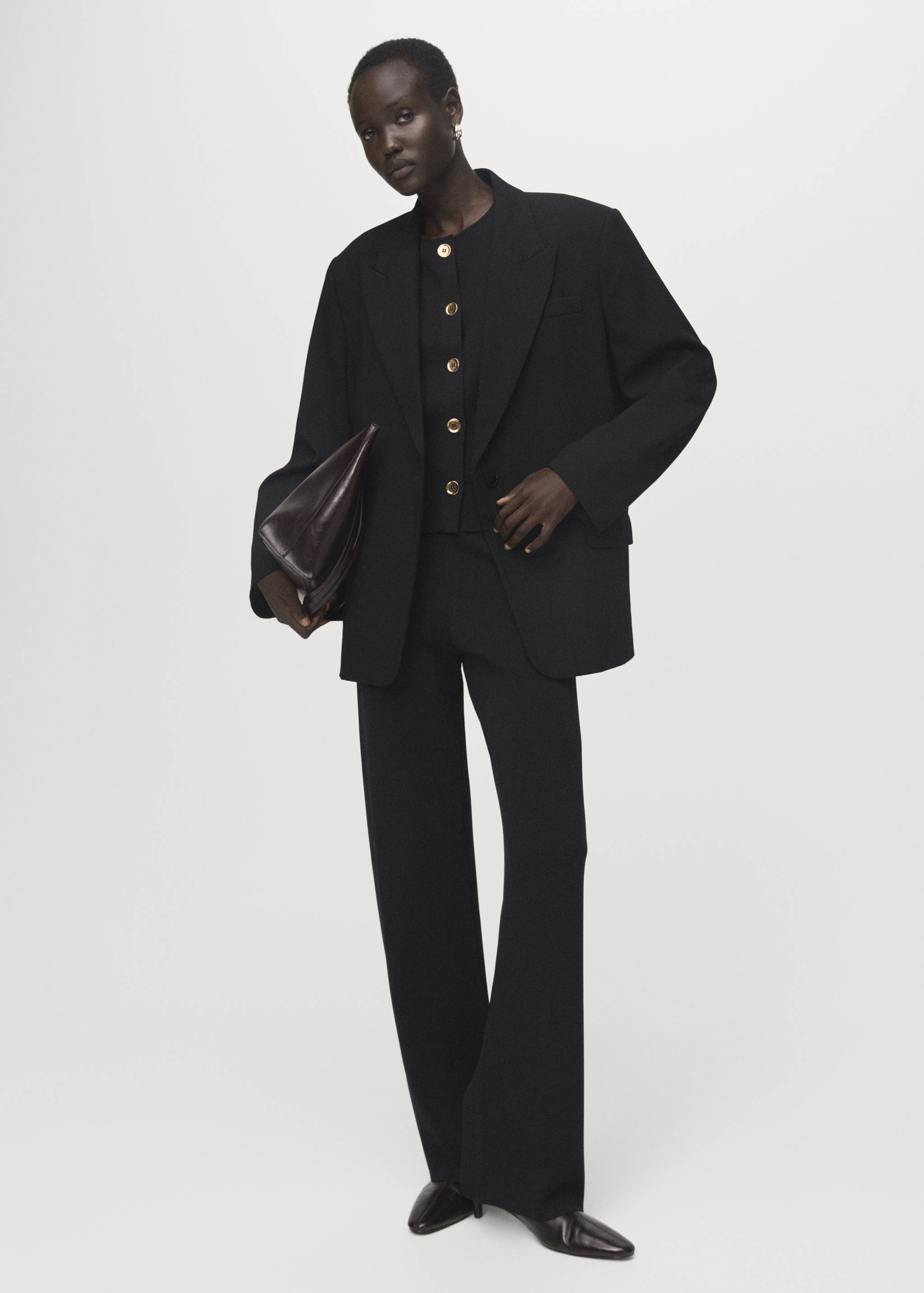 Pantalones negros de corte recto, combinados en un traje sastre con una americana oversize.