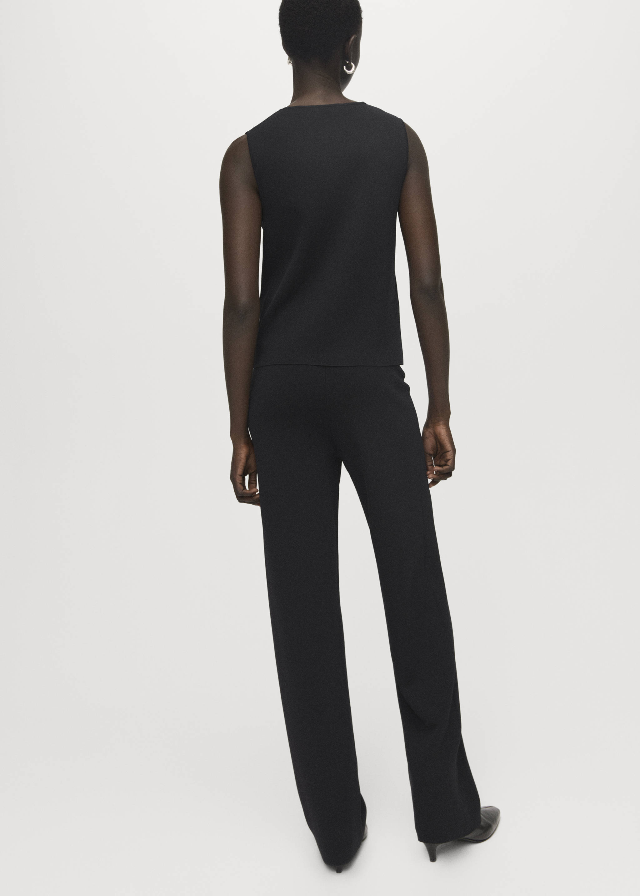Pantalones negros vistos de espaldas, combinados con un top a juego.