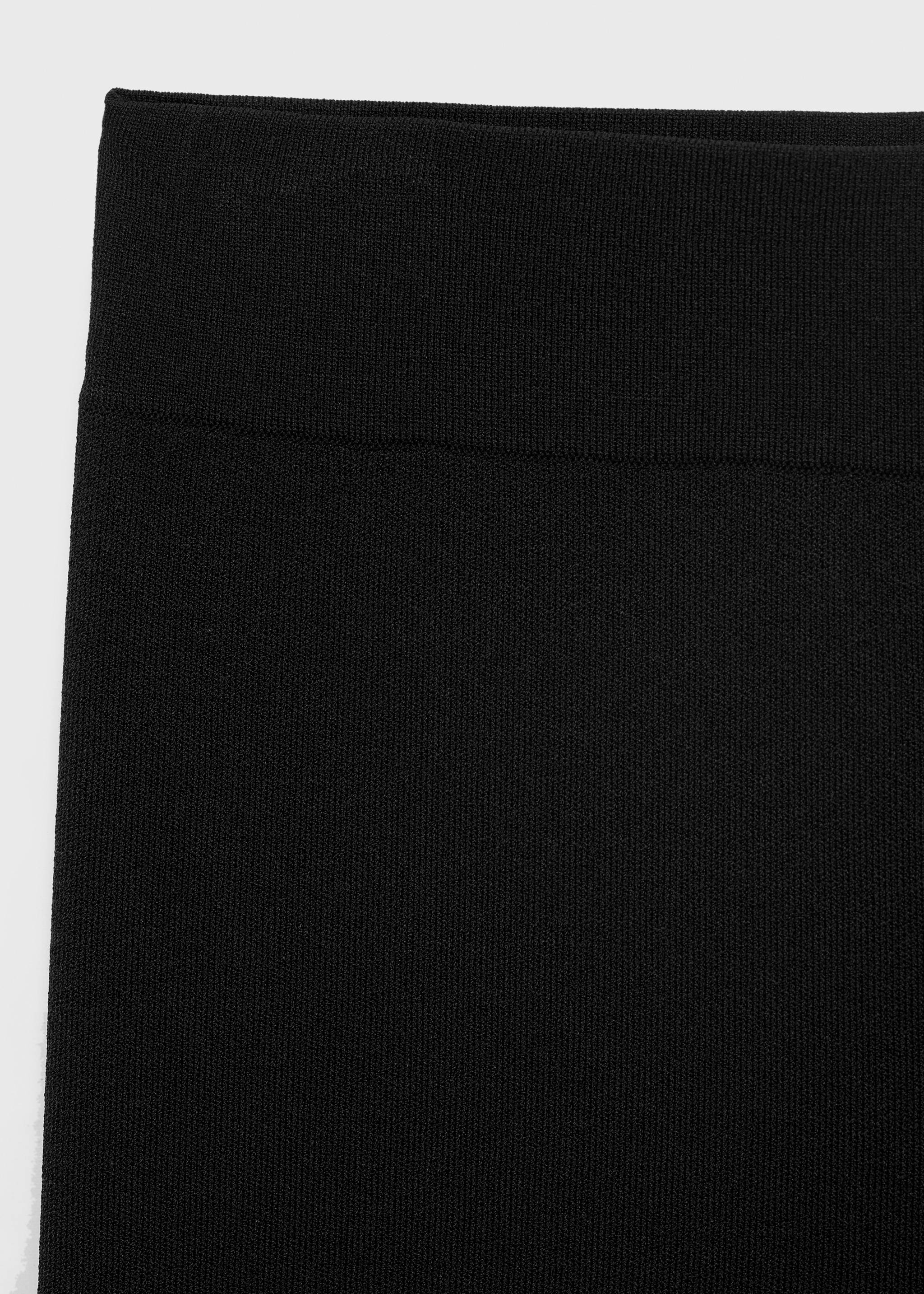 Detalle de la pretina de los pantalones de punto negros