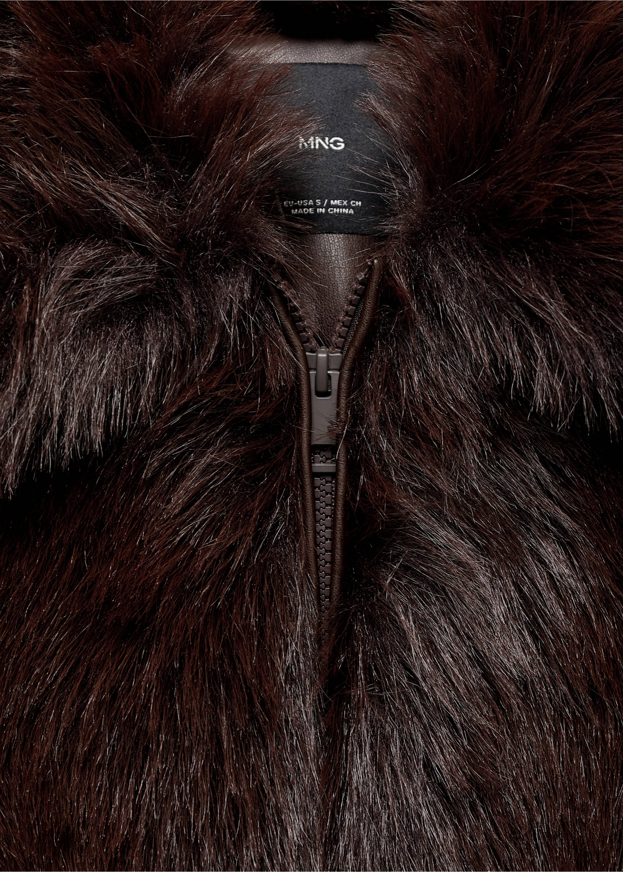 Close-up of a dark brown faux-fur jacket showing the zip fastening and brand label., Brown. Ref: 17086738-00.