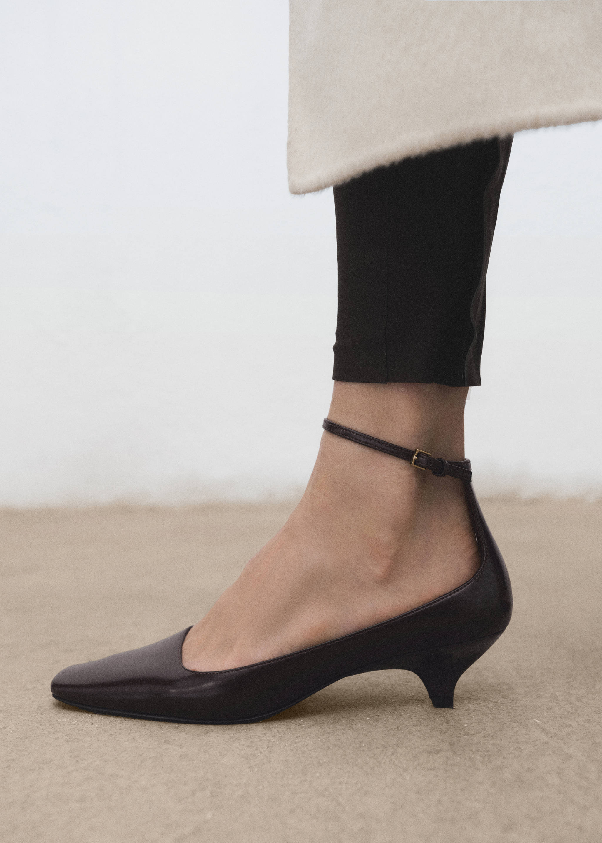 Dark brown leather kitten heel shoe with a pointed toe and ankle strap.