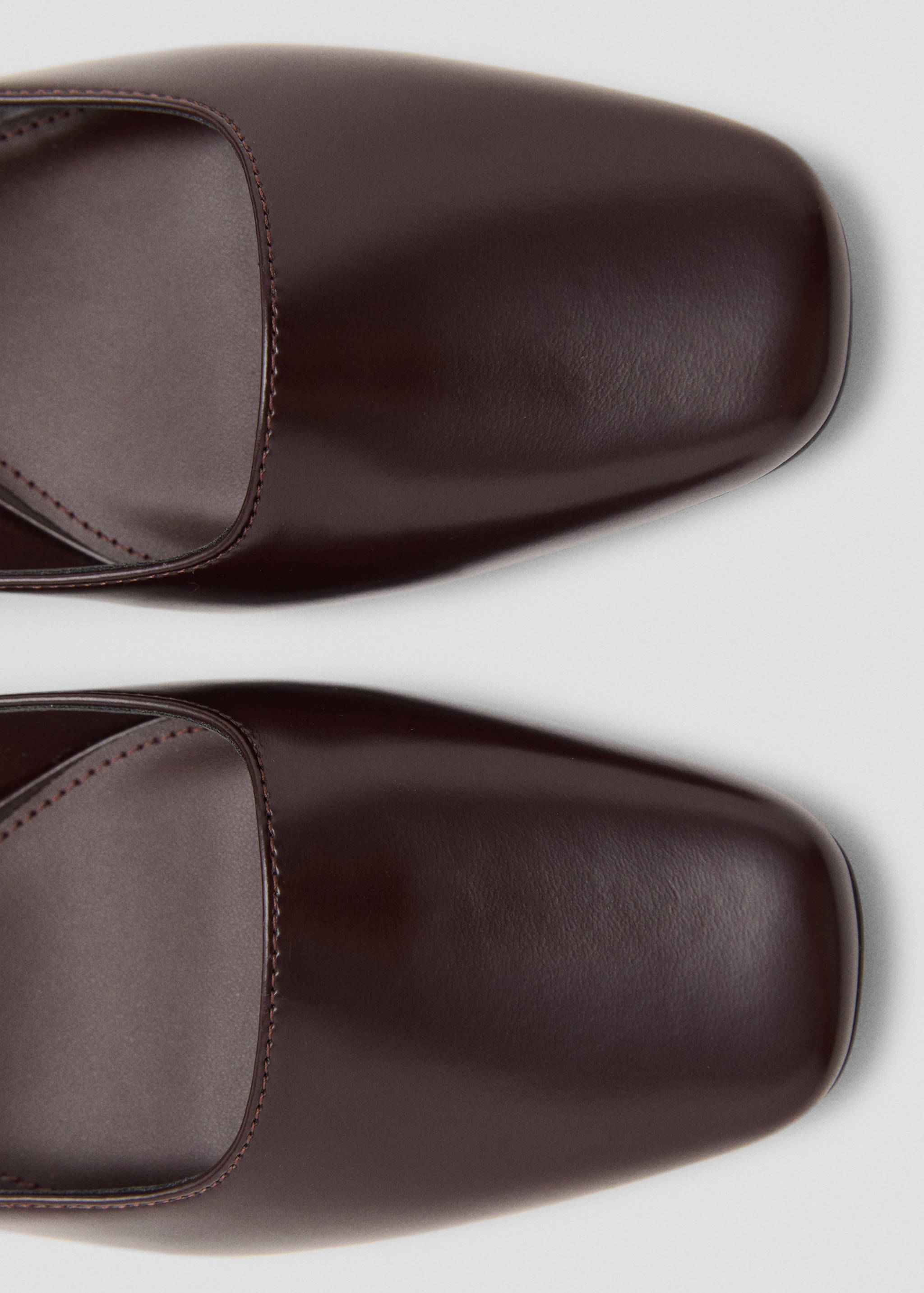 Close-up of brown shoes featuring a square toe.