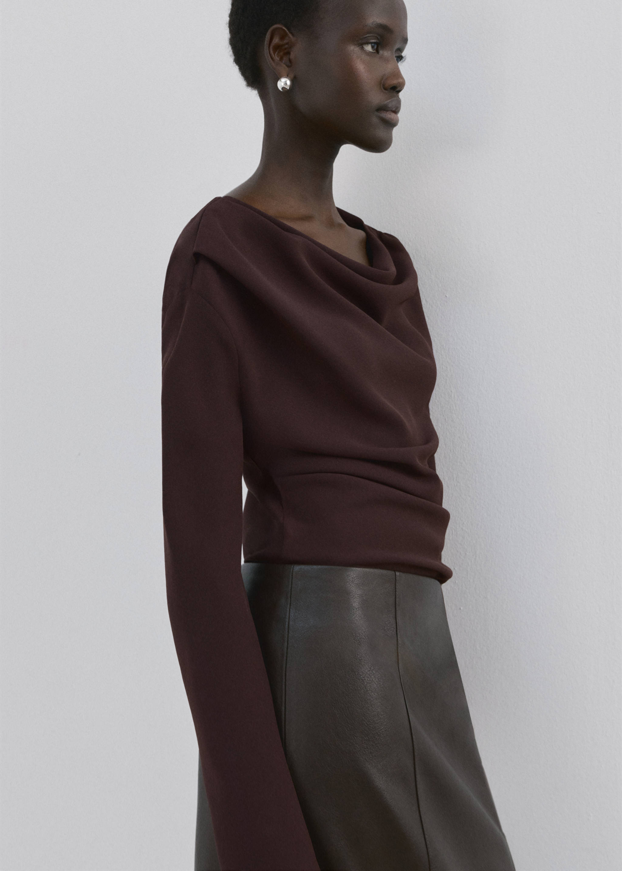 Dark brown long-sleeved blouse with an asymmetrical draped cowl neckline.