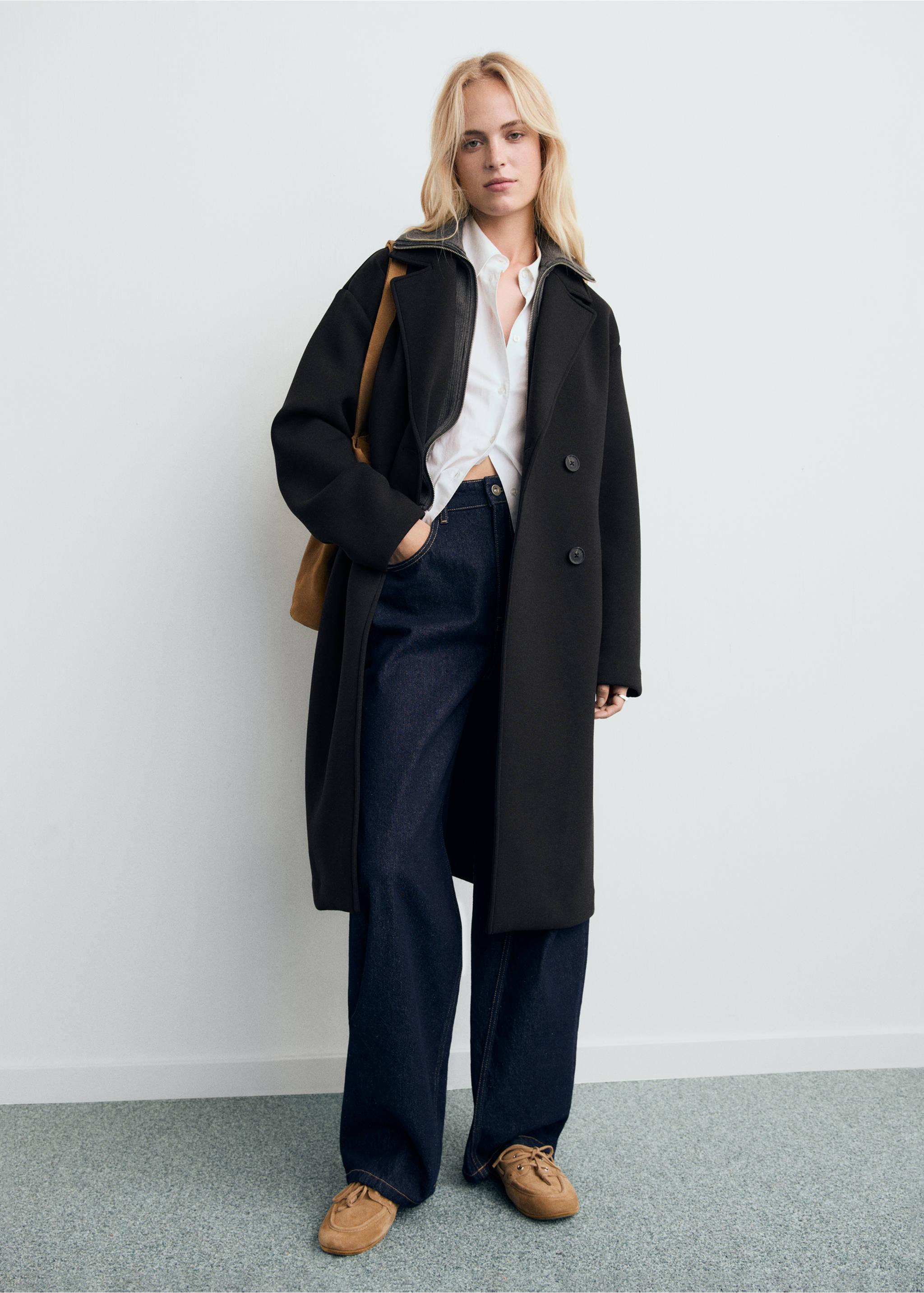Black long double-breasted coat with broad lapels and contrast collar trim, worn with a white shirt and denim trousers., Black. Ref: 17087801-00.