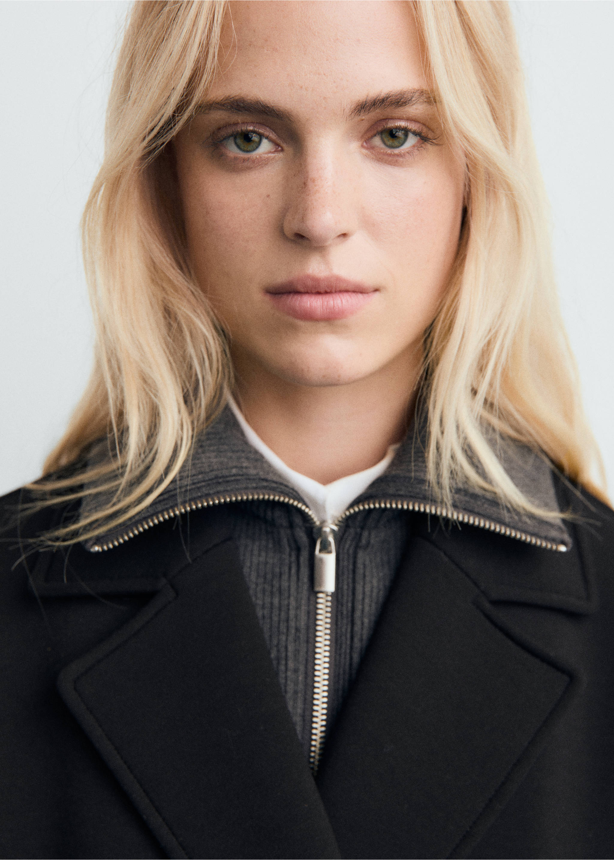 Close-up of a black coat with lapels and a grey ribbed zip collar., Black. Ref: 17087801-00.