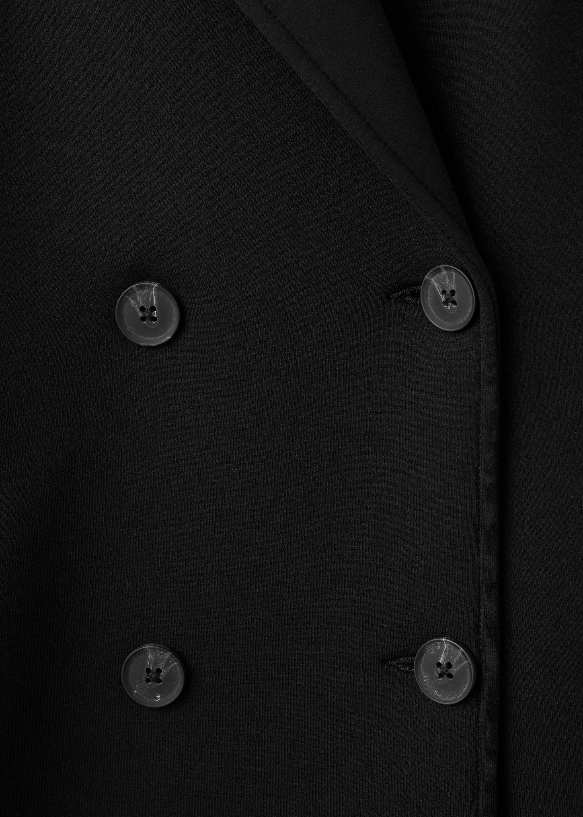 Close-up of the fabric and double-breasted button detail on a black coat., Black. Ref: 17087801-00.