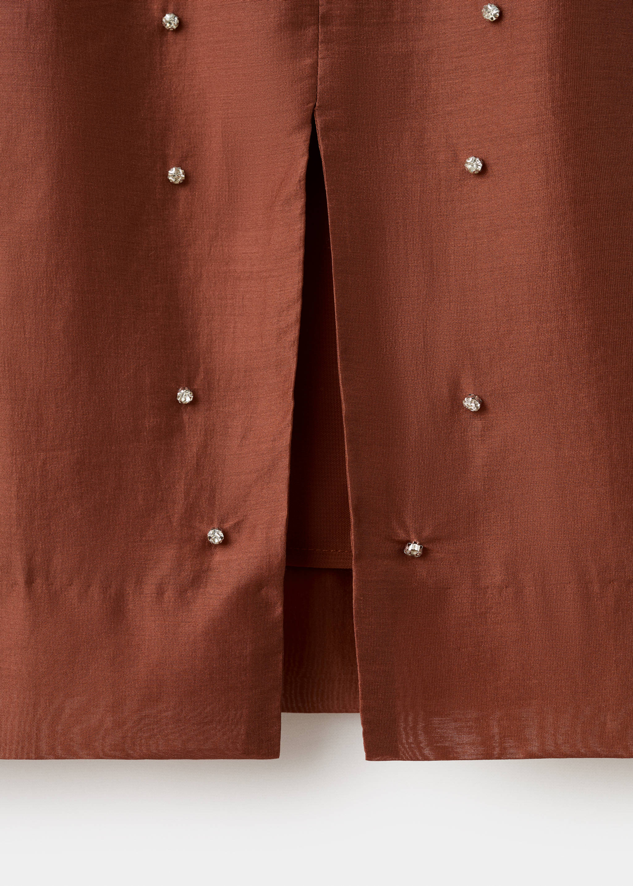 Brown skirt fabric detail with rhinestone embellishments