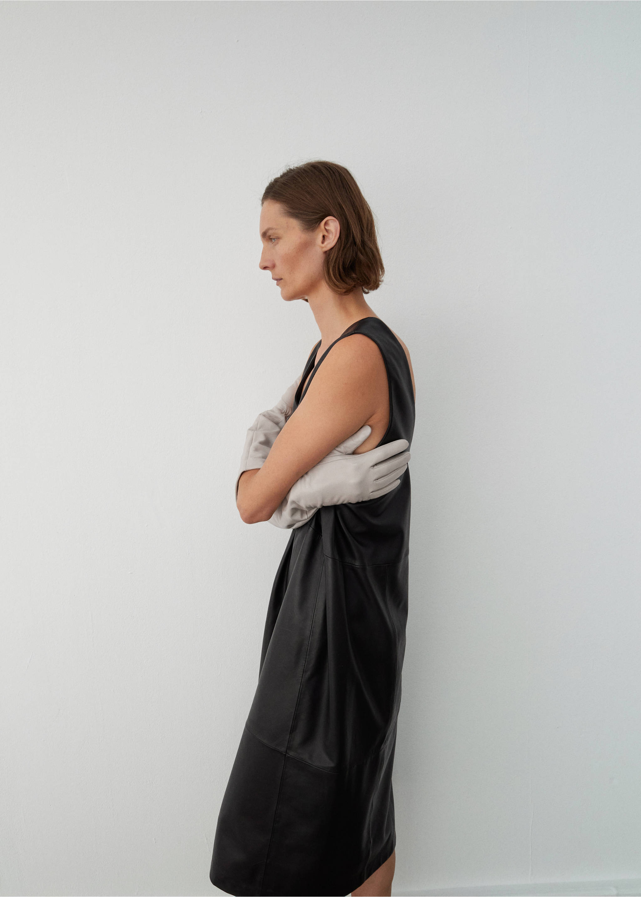 Sleeveless black midi dress worn with long grey gloves., Black. Ref: 17096357-00.
