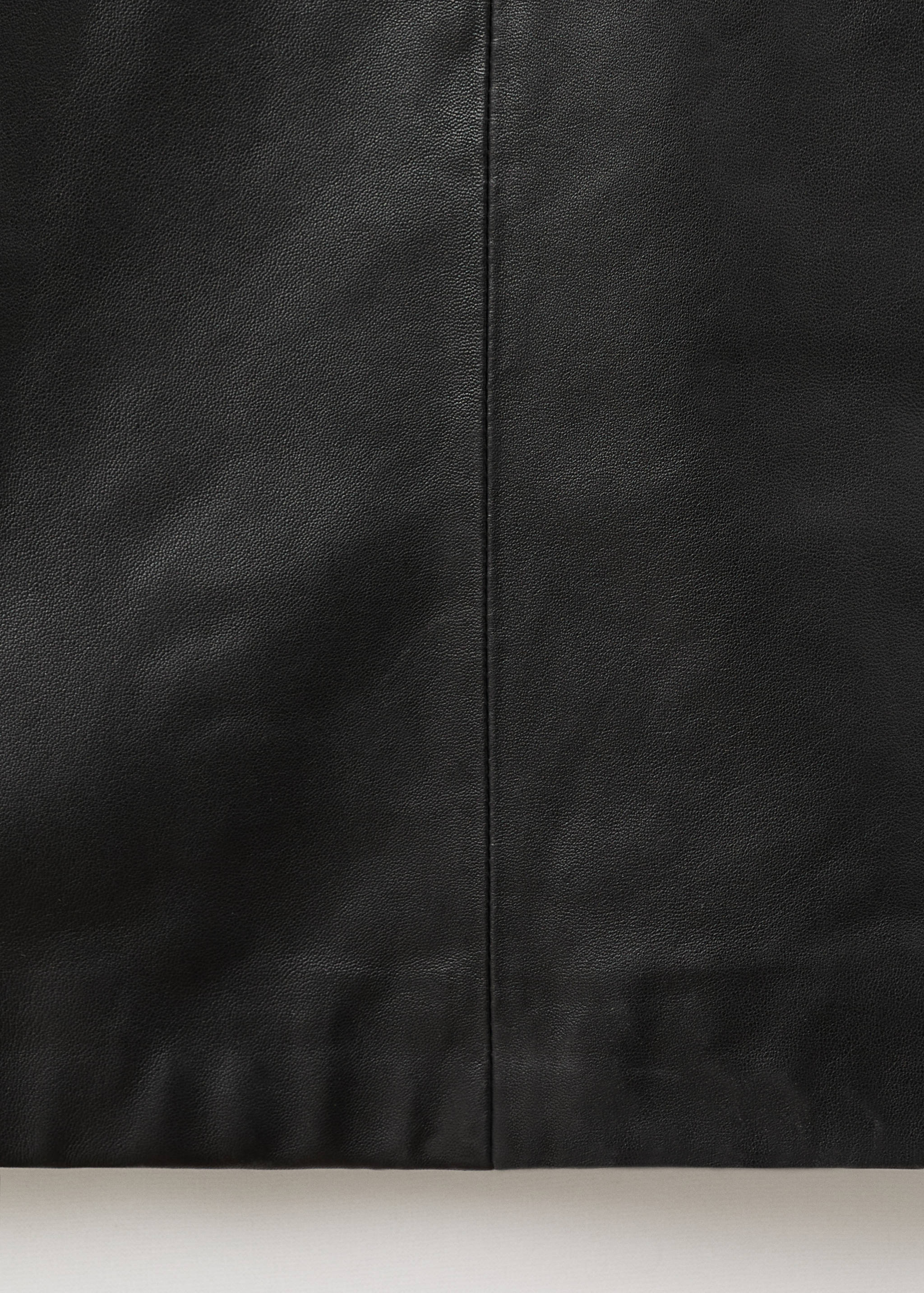 Close-up of a black dress detail showing the vertical center seam.