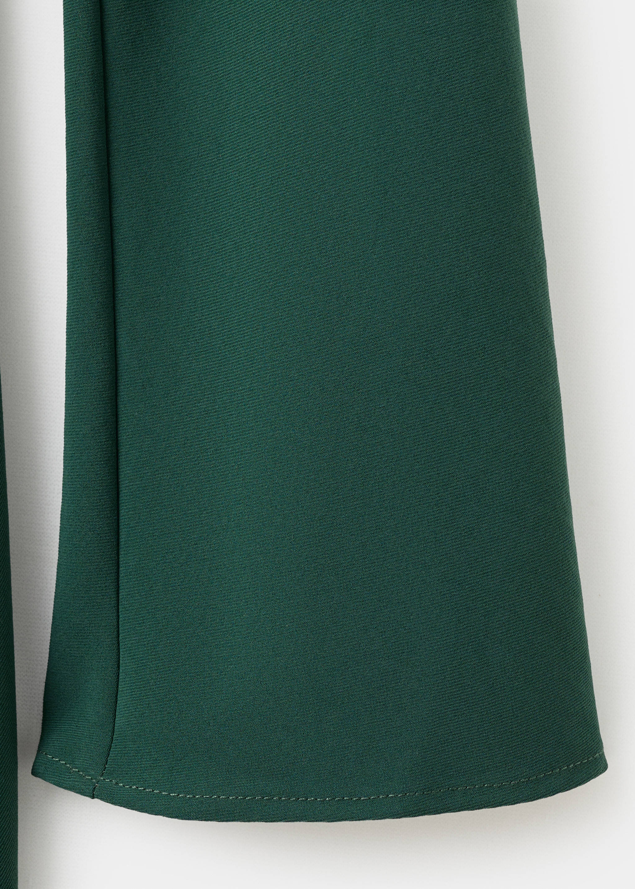 Detalle de la textura del tejido verde oscuro de un vestido.