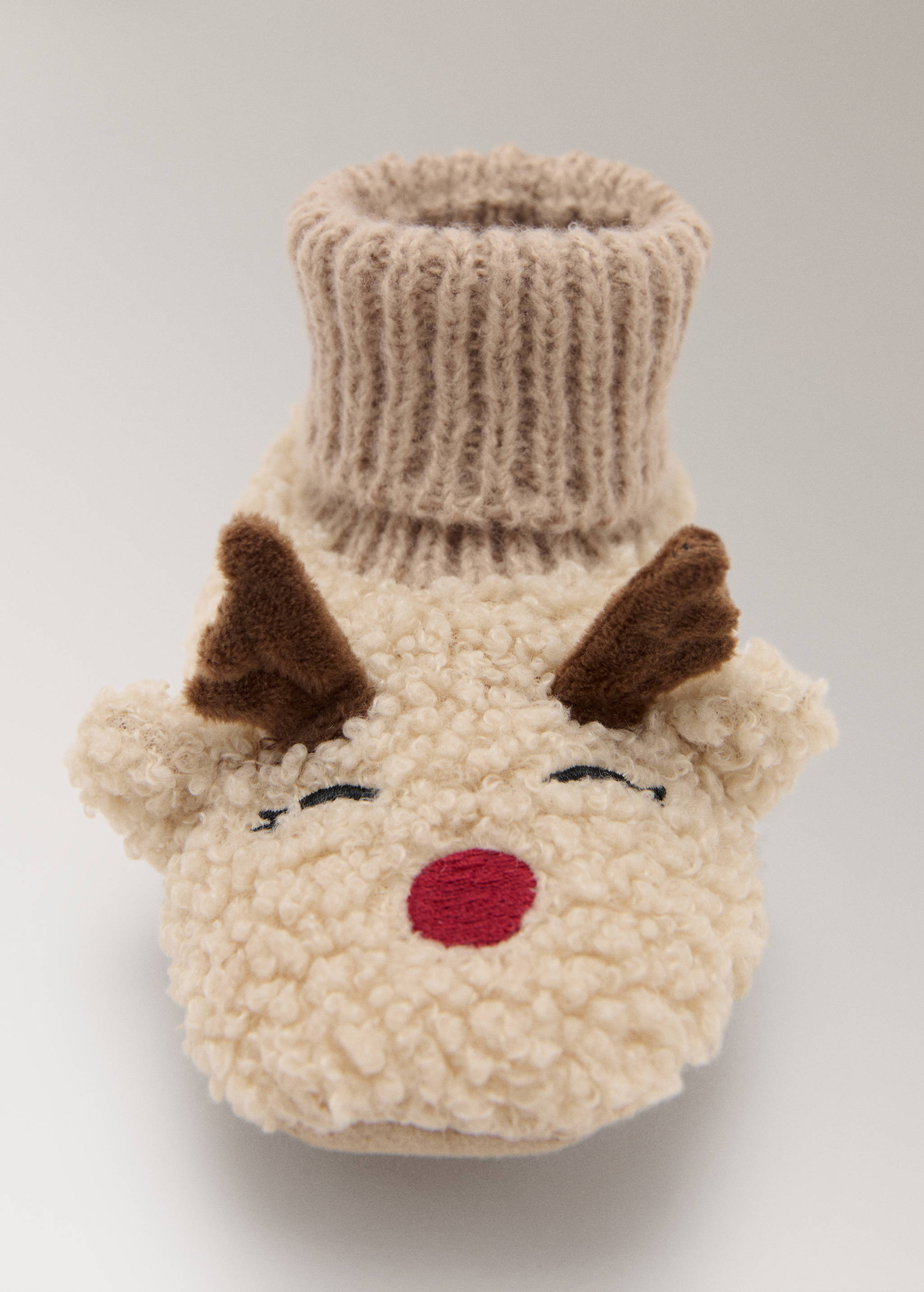 Cream faux-shearling home slipper with reindeer face embroidery and ribbed knit cuff.