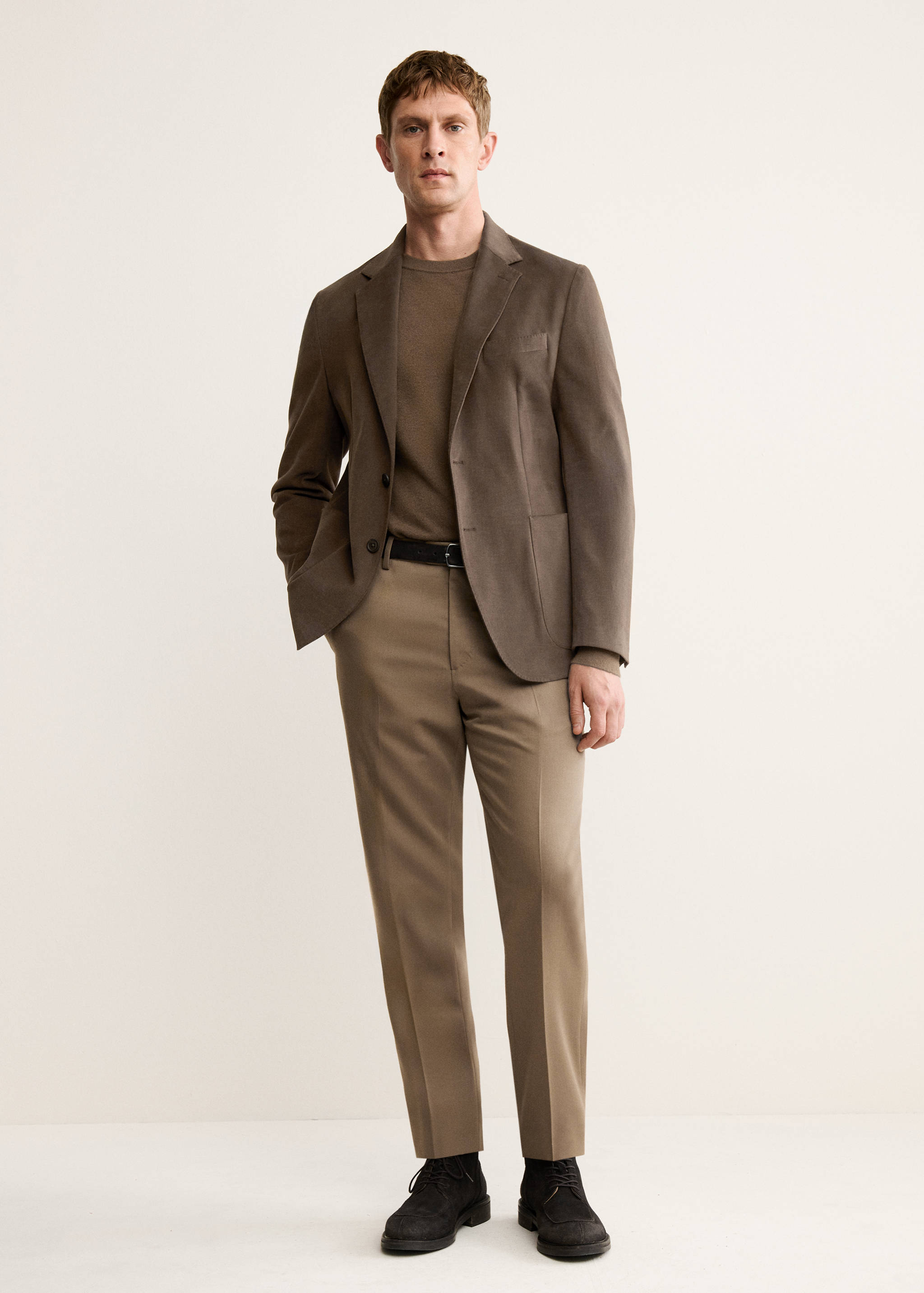 Brown blazer worn with a brown jumper and light brown trousers.