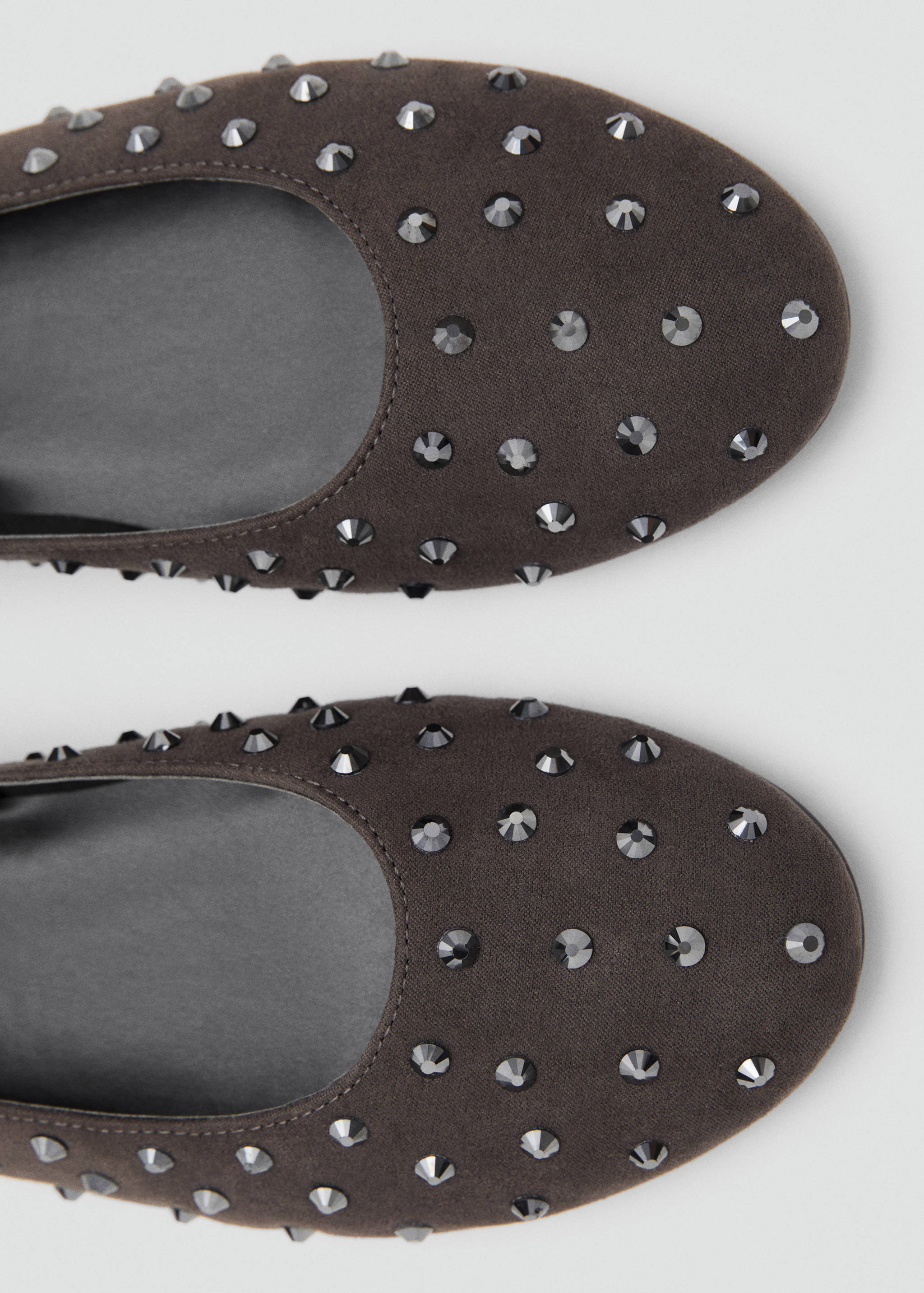 Close-up of dark brown studded flat shoes.