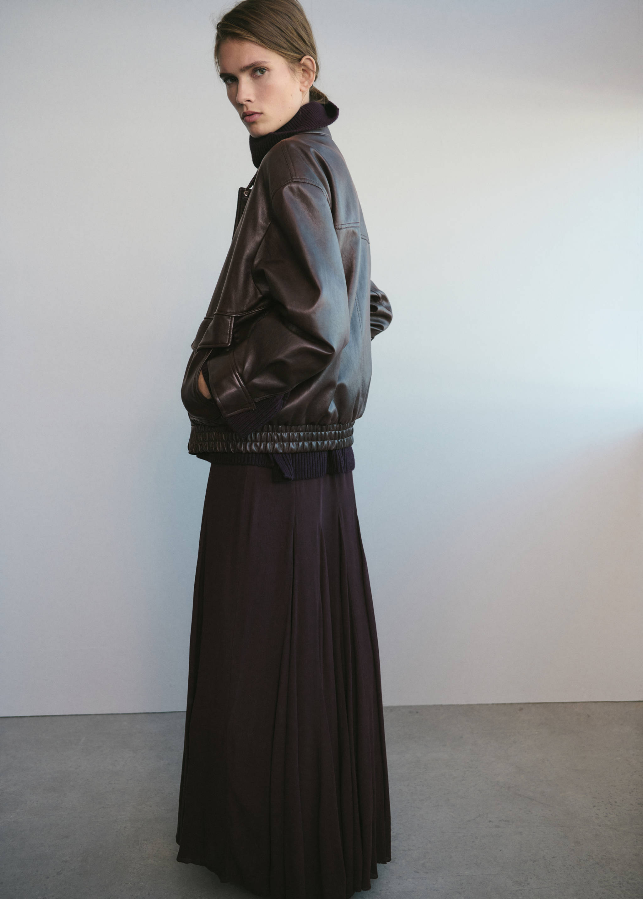 Dark brown oversized leather jacket with flap pockets and ribbed hem.