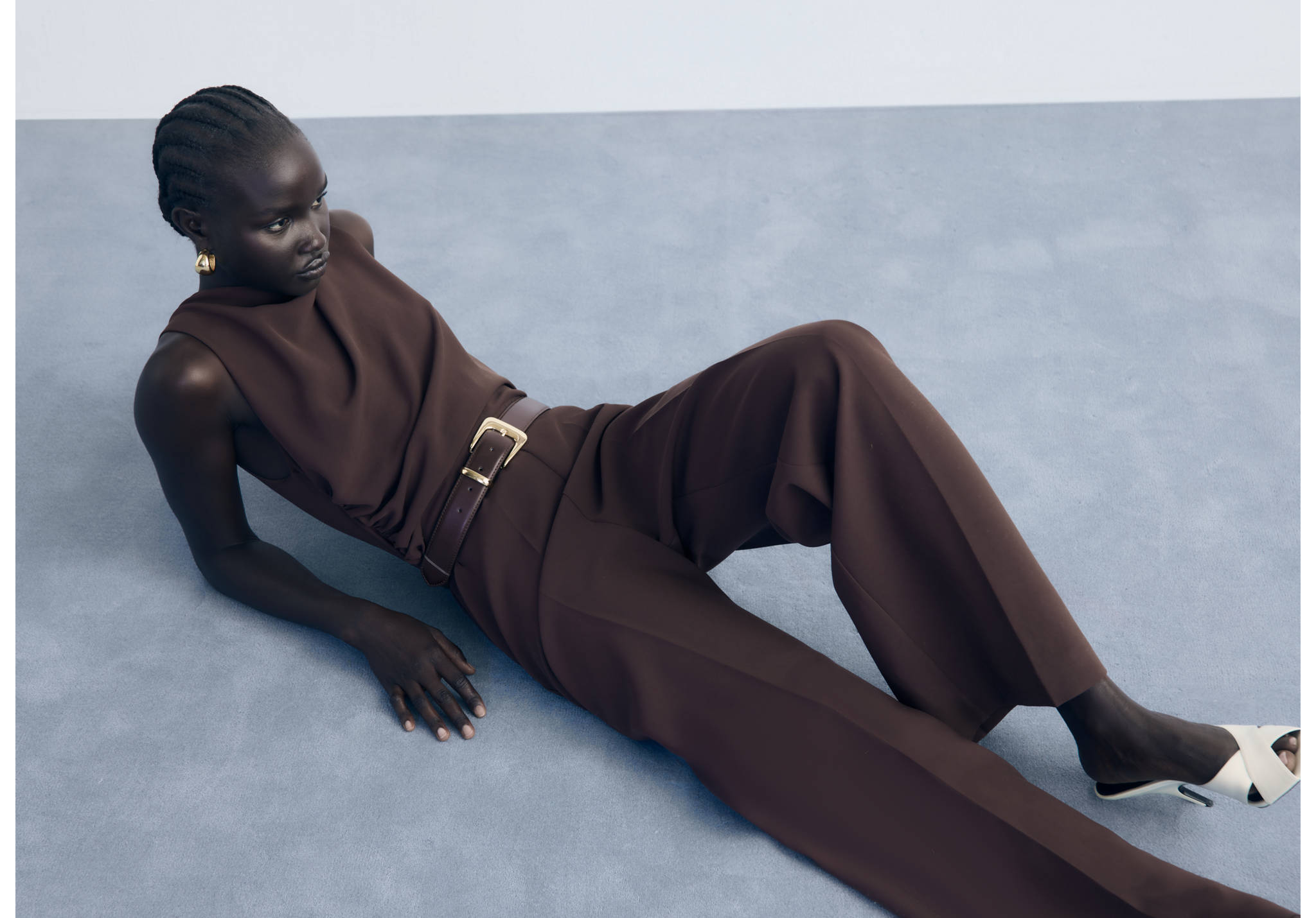Dark brown sleeveless jumpsuit with a rounded neckline and draped bodice.