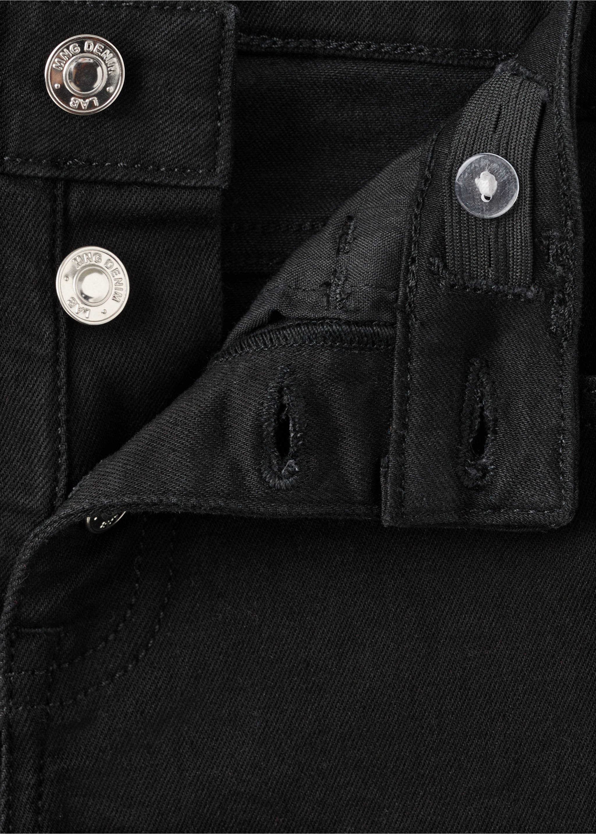 Close-up of black denim jeans waistband and metal button fly., Black denim. Ref: 27001257-00.