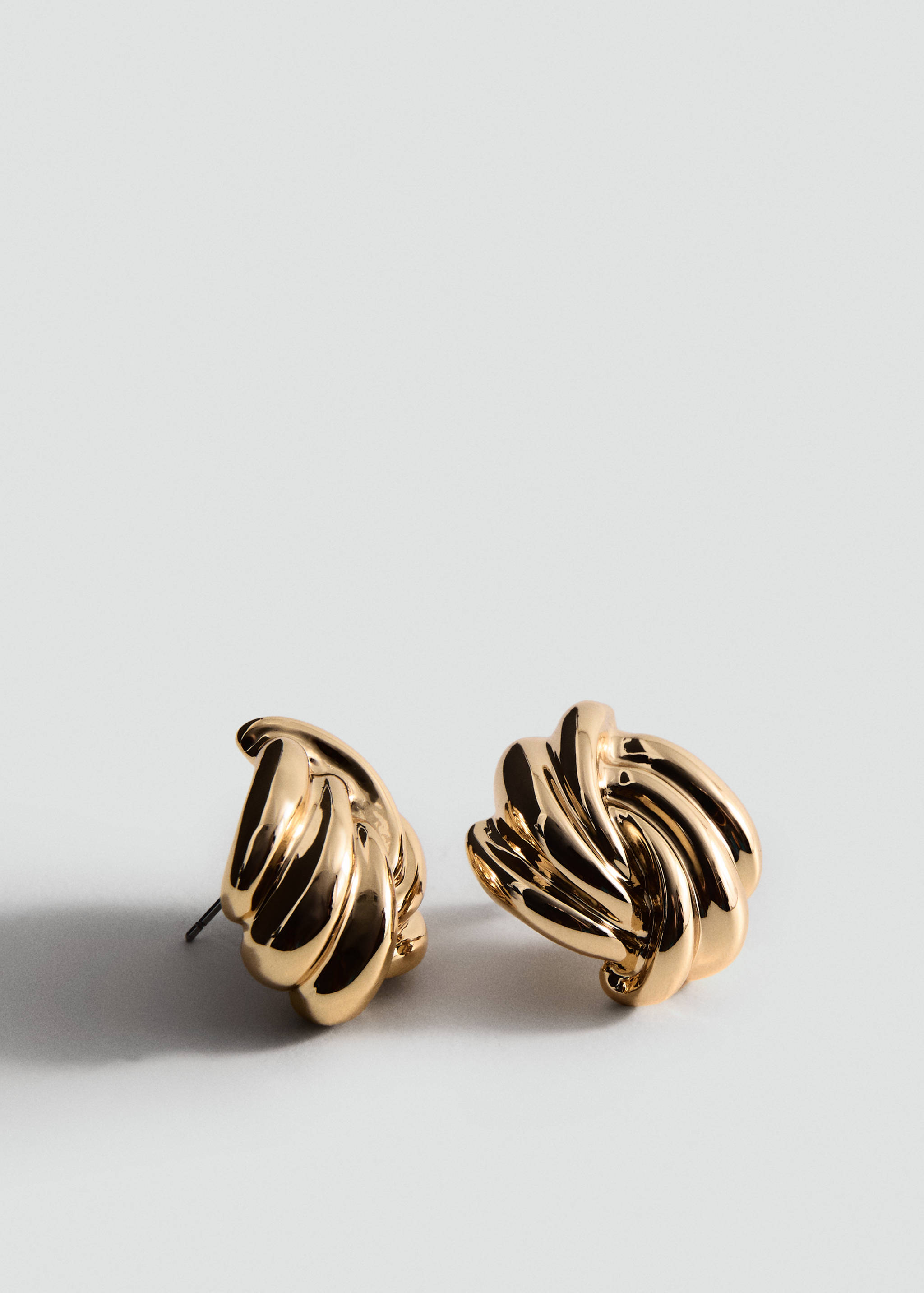 Gold-coloured metallic earrings with a rounded, interwoven braided design.