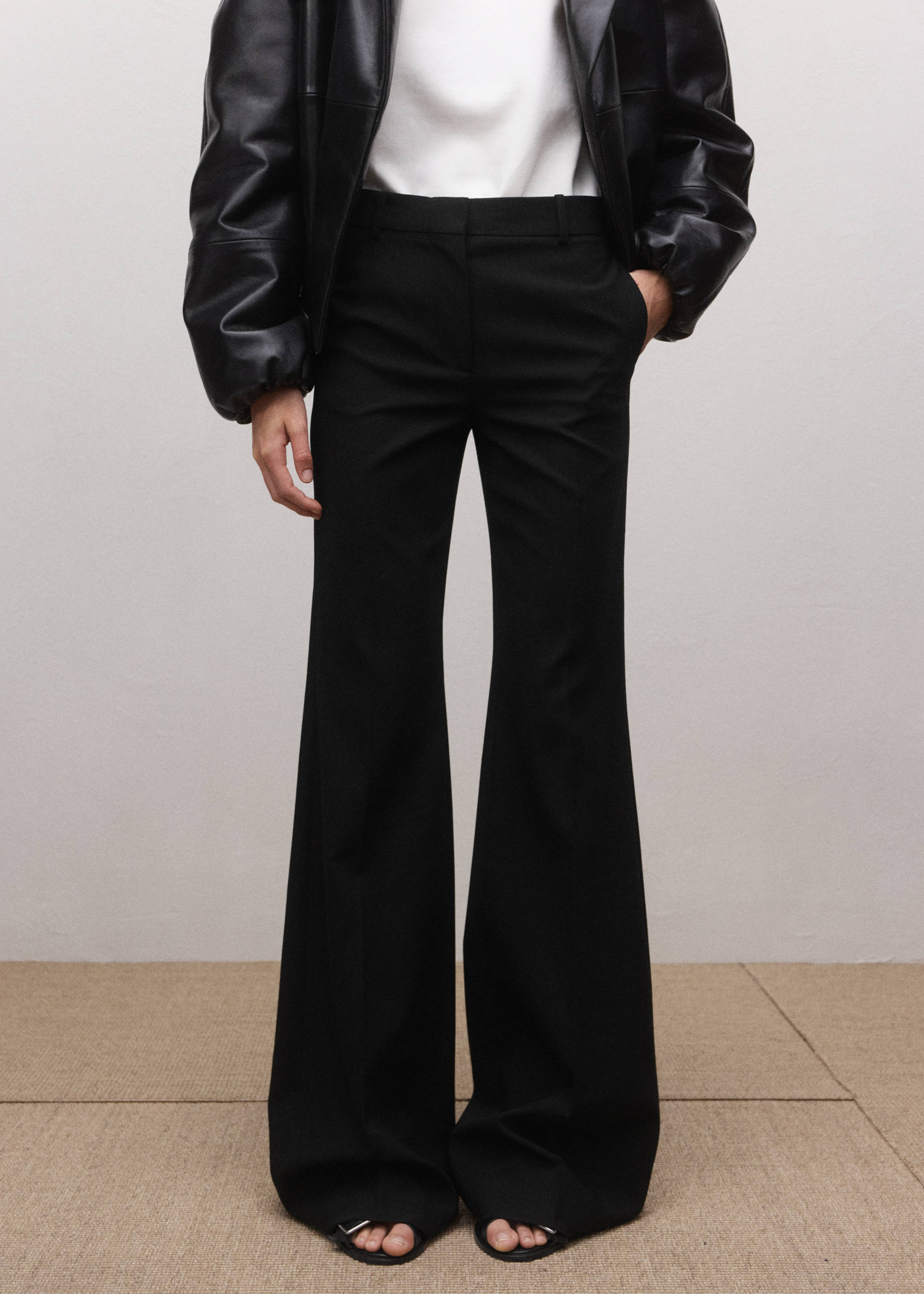 Black flared trousers with a mid-rise waist and structured waistband.