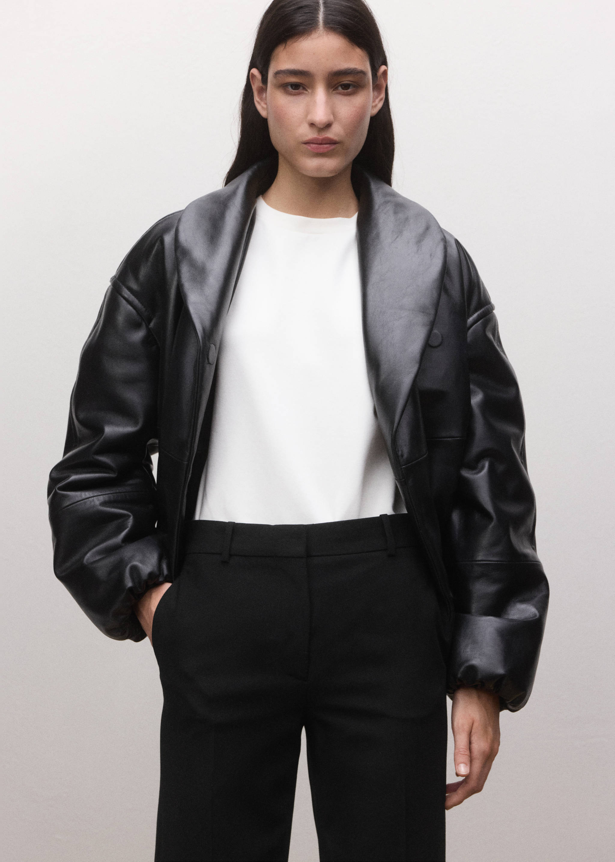 Black trousers with belt loops, styled with a white top and black leather jacket.