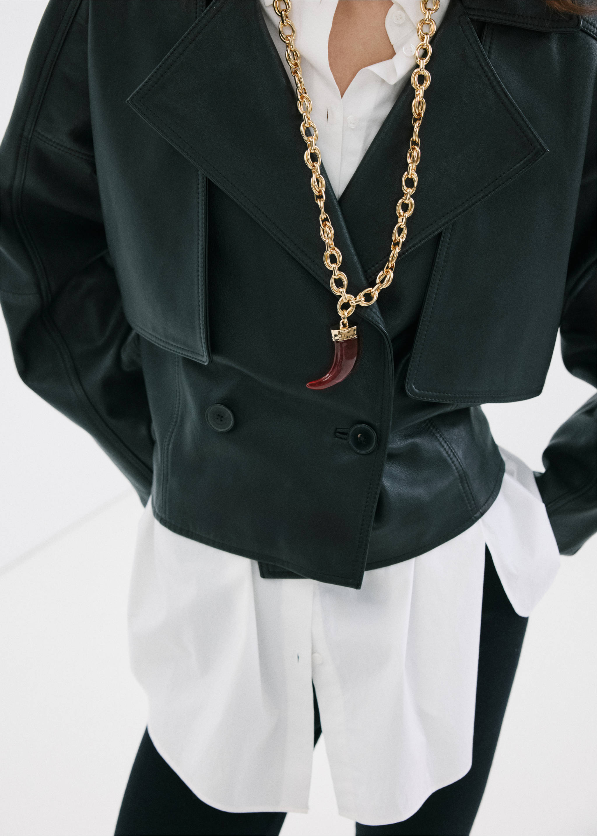 Chunky gold chain necklace with a red horn pendant worn over a leather jacket., Gold. Ref: 27004787-00.