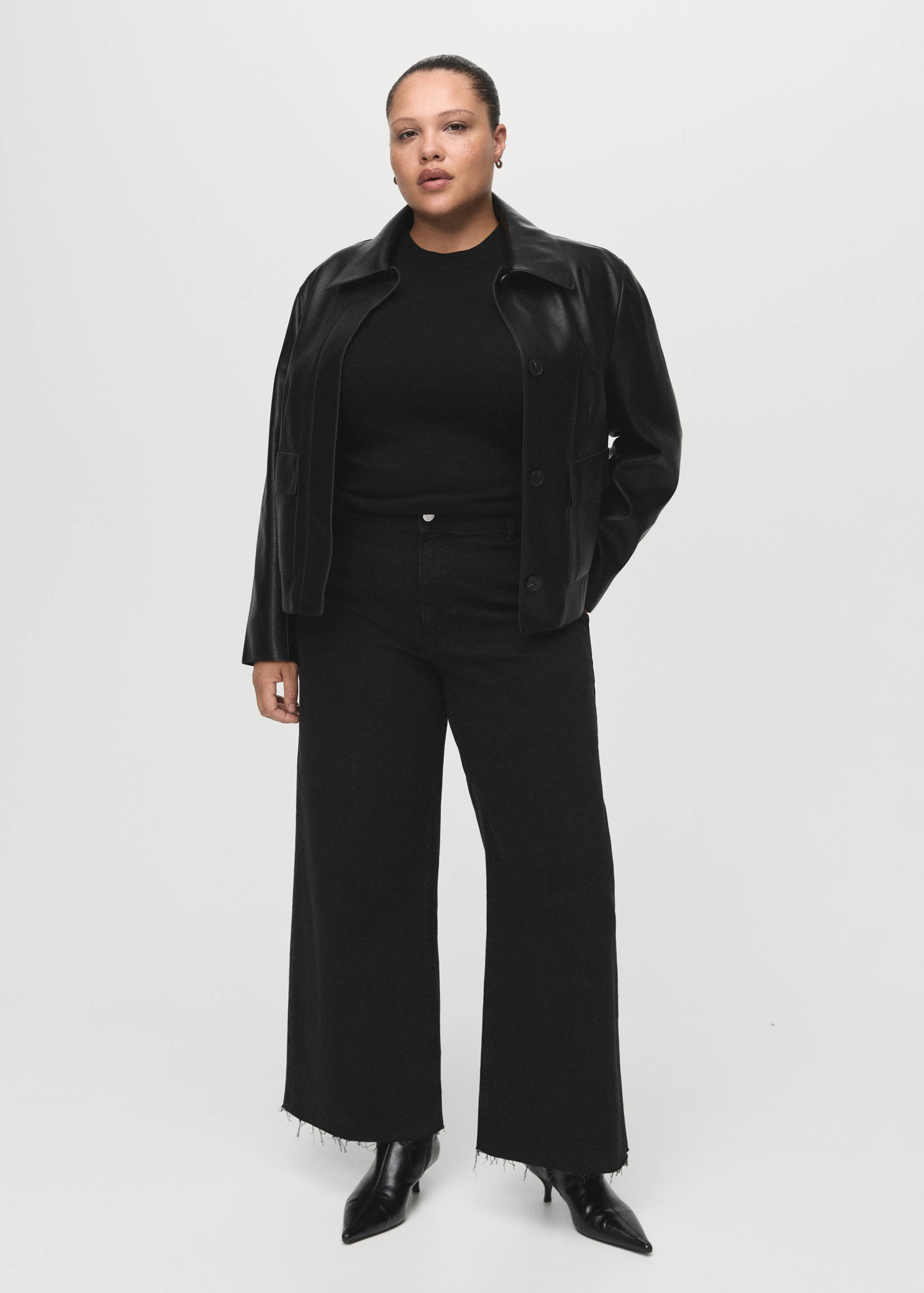 Black wide-leg denim trousers with raw hems, worn with a black leather jacket and top.
