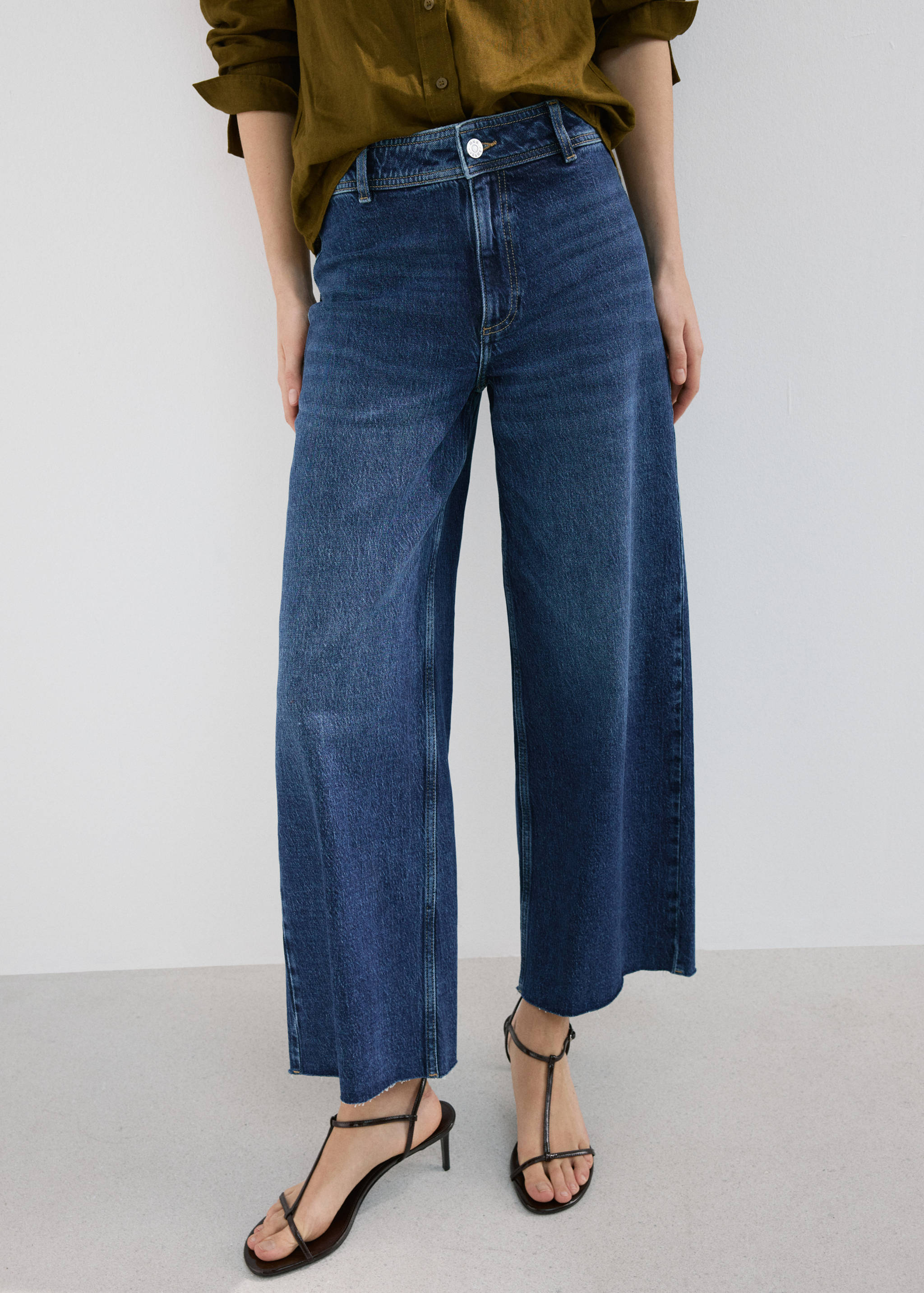 Dark blue wide-leg denim trousers with a high waist and raw hems.