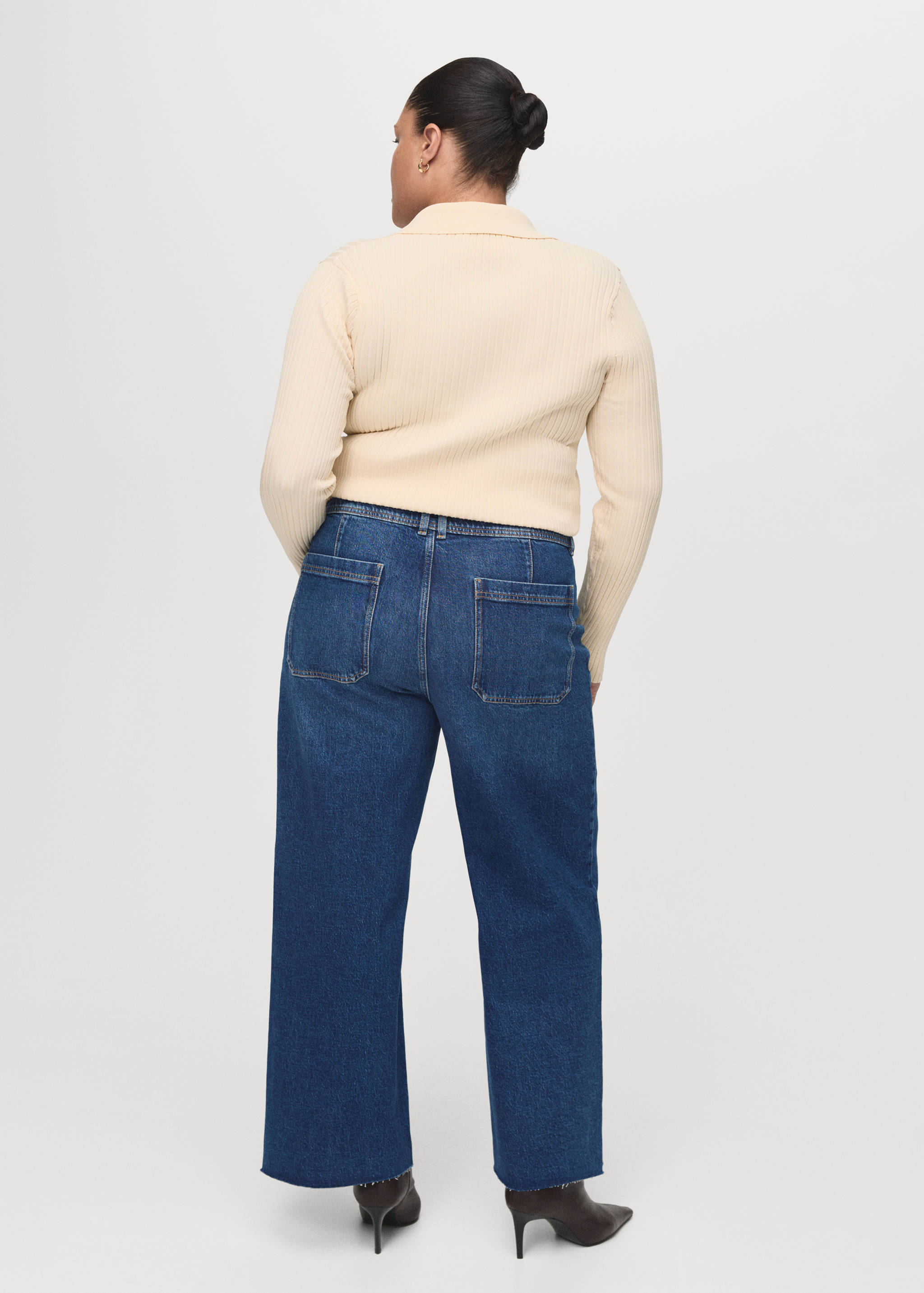 Blue denim trousers in a straight-leg fit with back patch pockets, seen from the back.