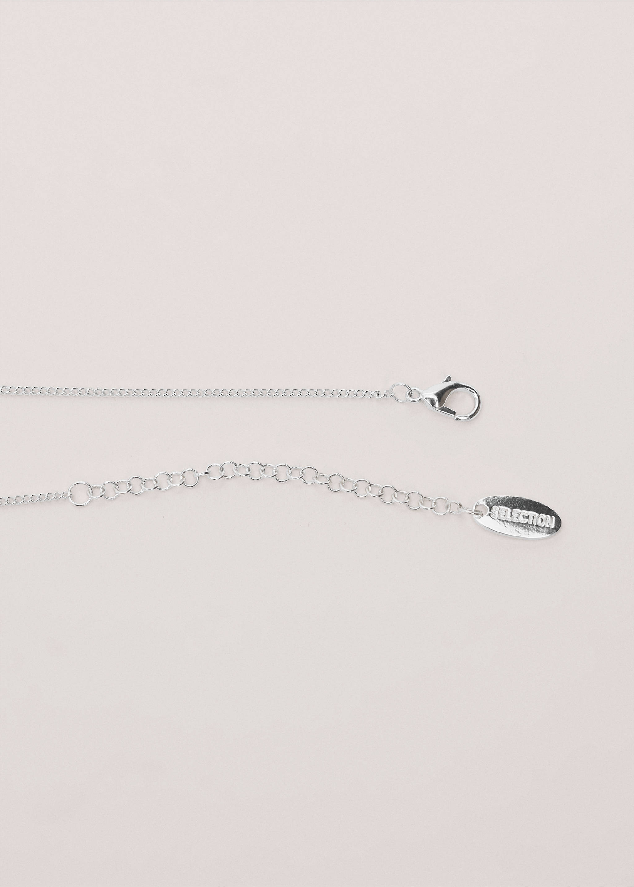 Close-up of a silver-coloured chain necklace featuring a lobster clasp, extension chain, and branded tag., Silver. Ref: 27014446-00.