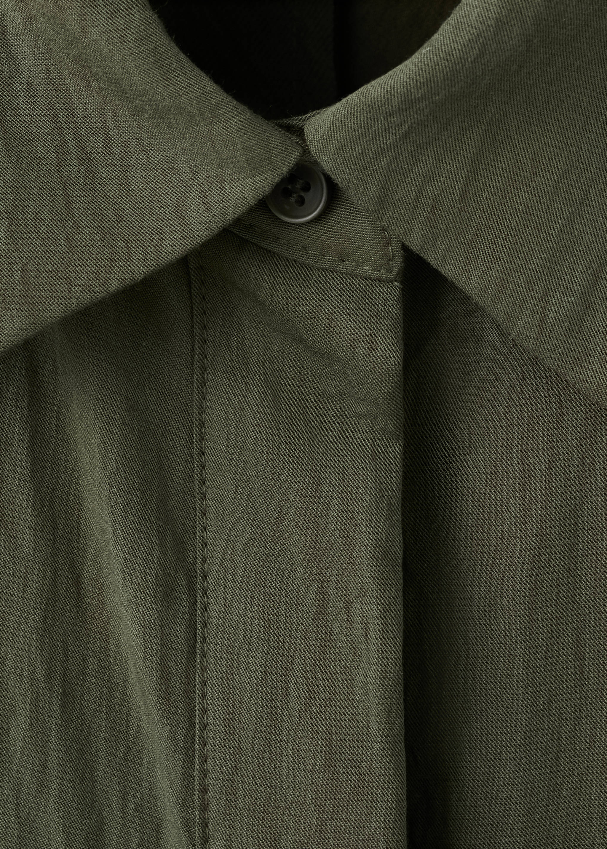 Close-up of a dark khaki green dress collar and button placket detail.