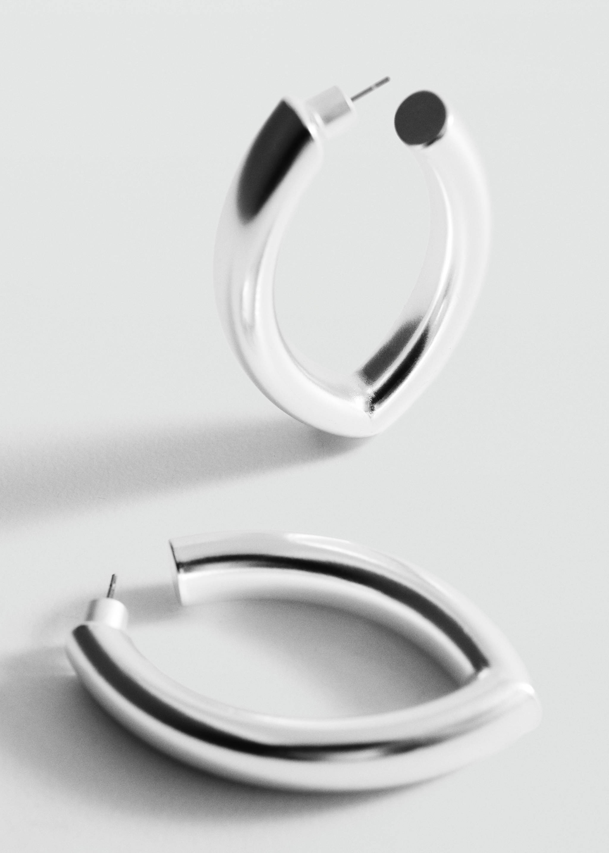 Chunky silver-toned hoop earrings with a polished, thick oval profile.