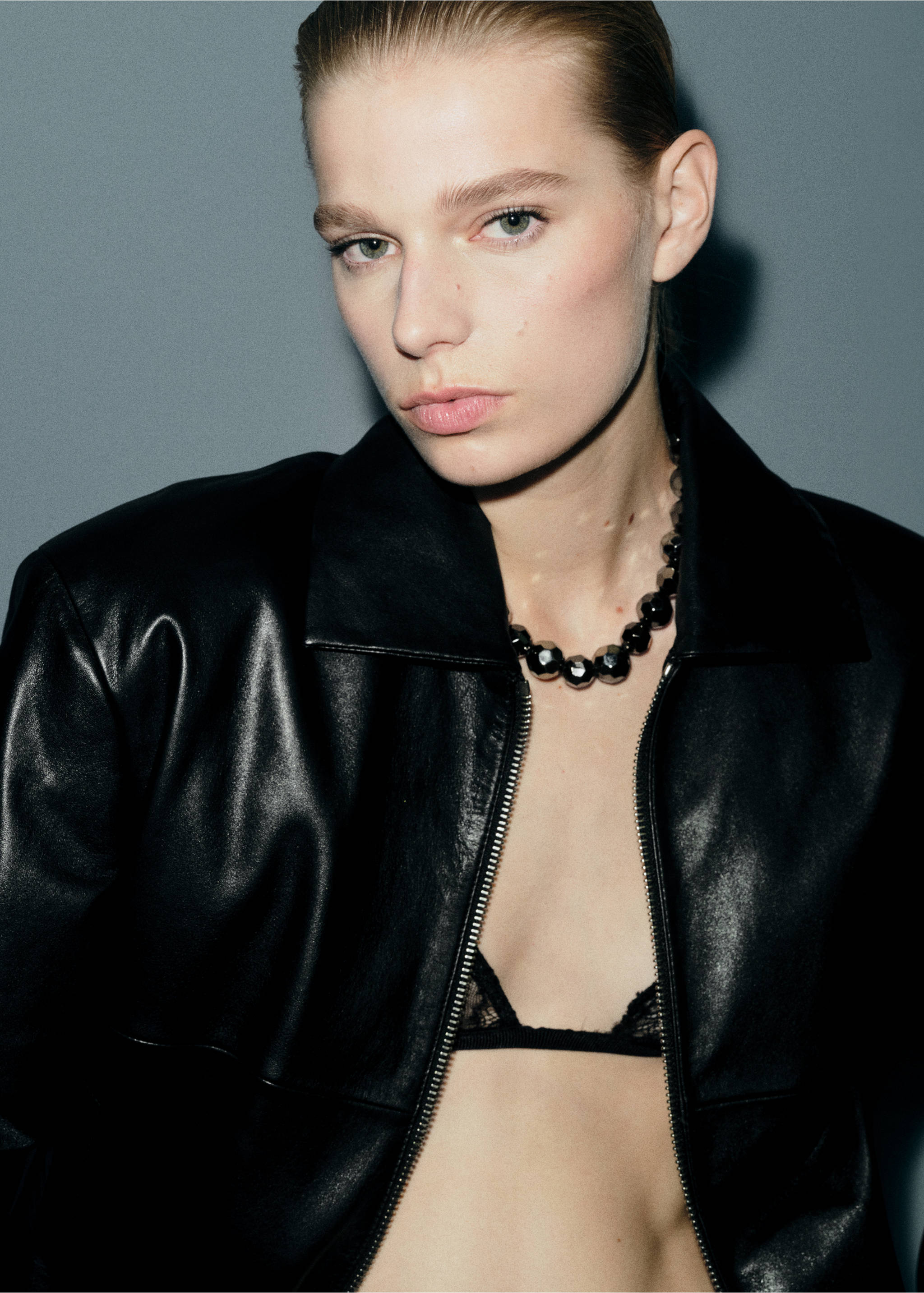 Black collared jacket with front zip, worn with a beaded necklace., Silver. Ref: 27021228-00.
