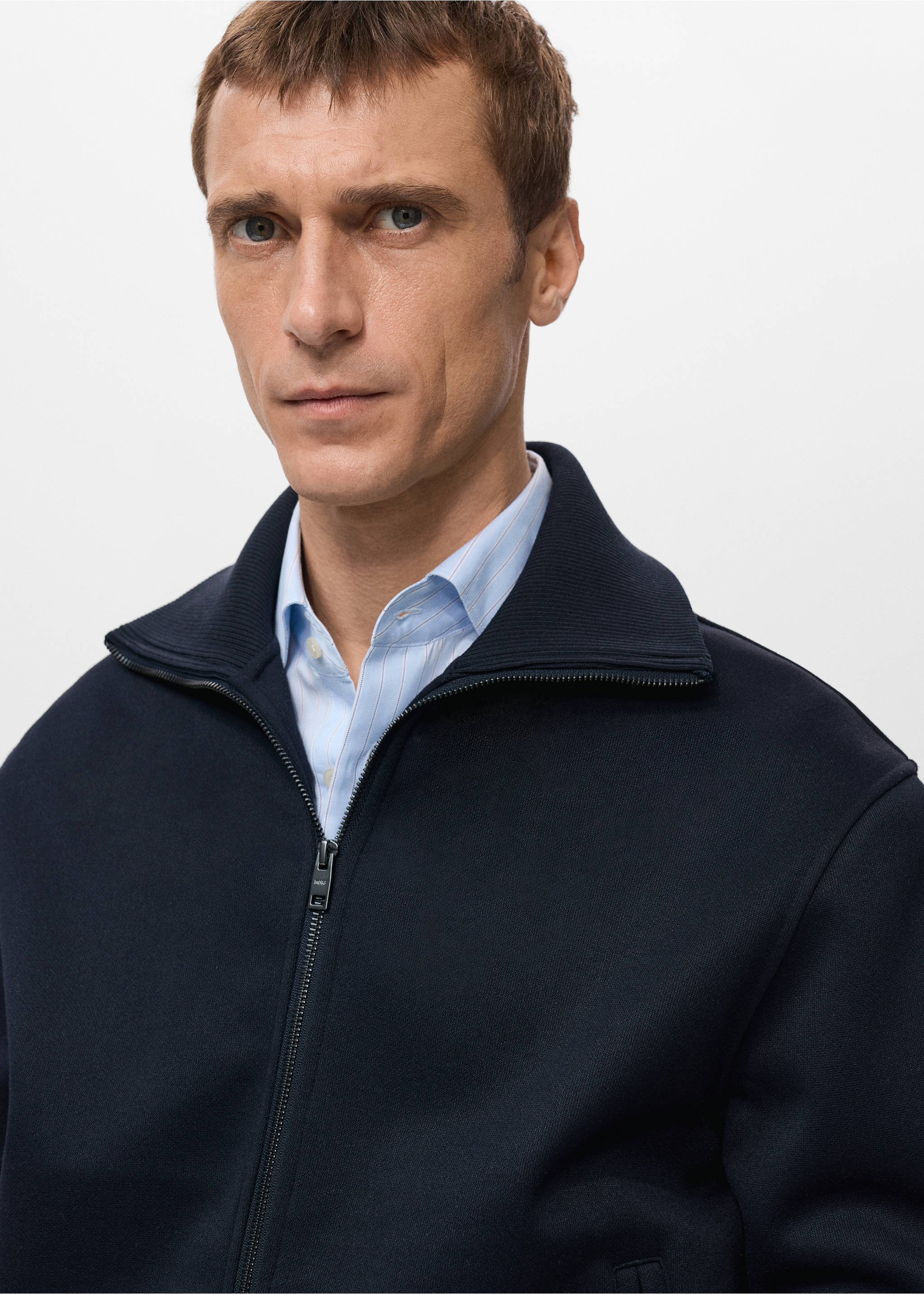 Navy blue zip-up sweatshirt with a ribbed high collar, worn over a striped shirt., Navy. Ref: 27021261-00.